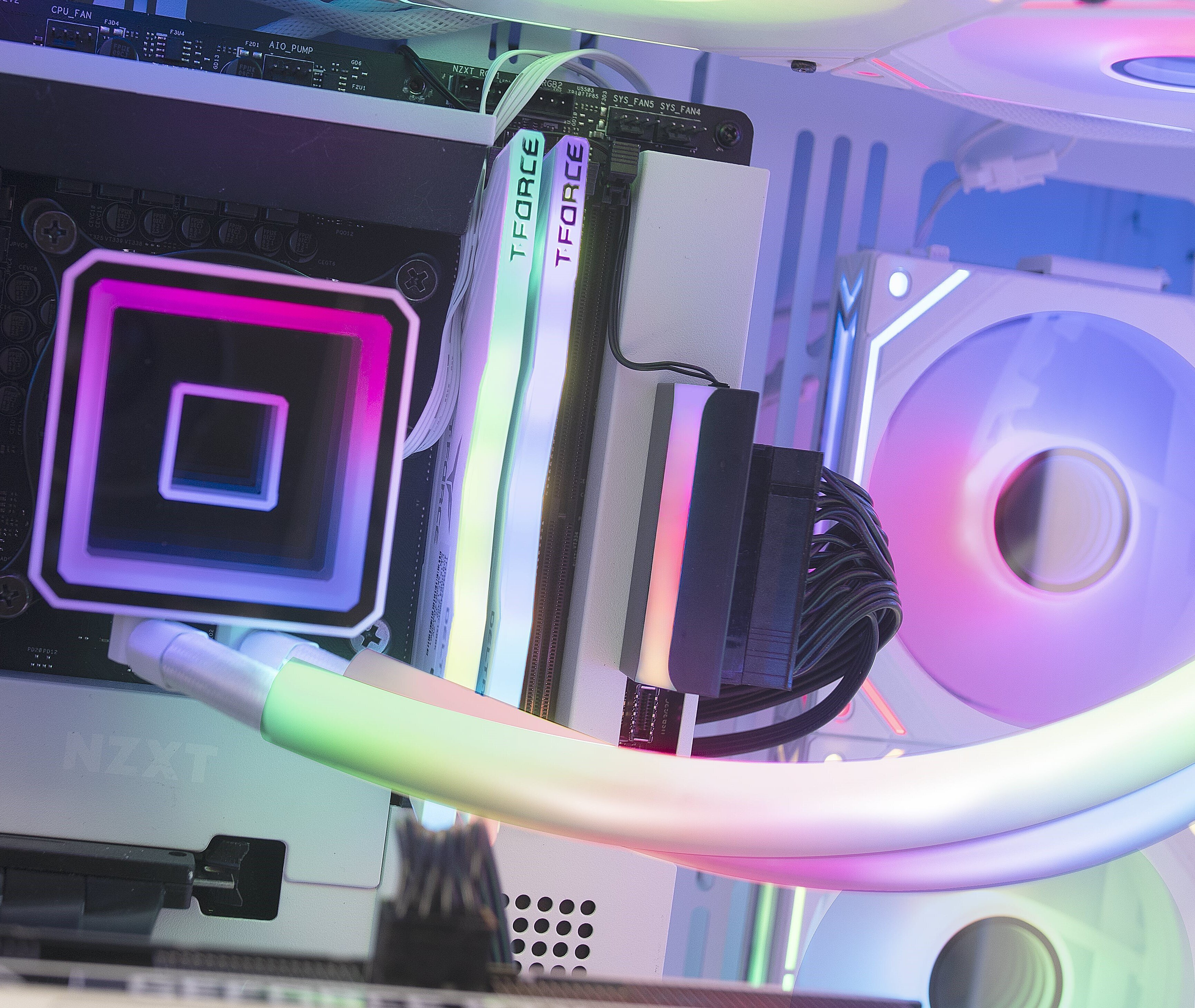 Dentro de una caja de computadora. Componentes: placa base, RAM, refrigerador líquido y ventilador.
