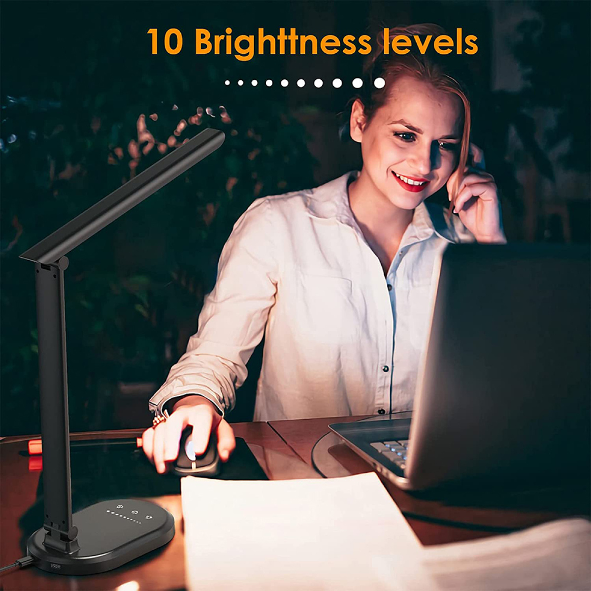 Eine Frau benutzt eine schwarze Schreibtischlampe, arbeitet nachts an einem Laptop, mit 10 Helligkeitsstufen.