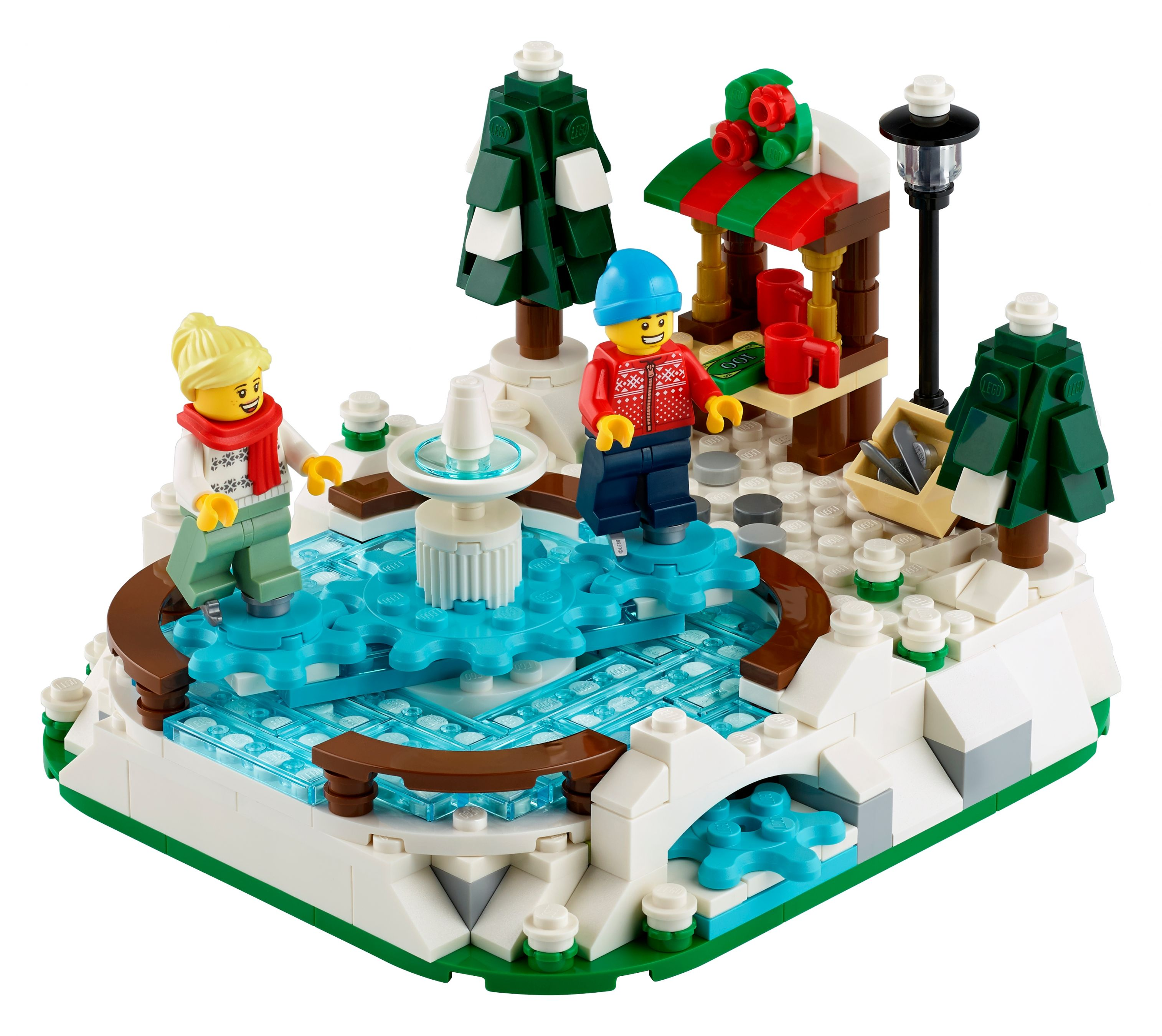 Lego-Set einer Winterszene mit Brunnen, Figuren und einem Marktstand. Die Szene hat Schnee und Weihnachtsbäume.