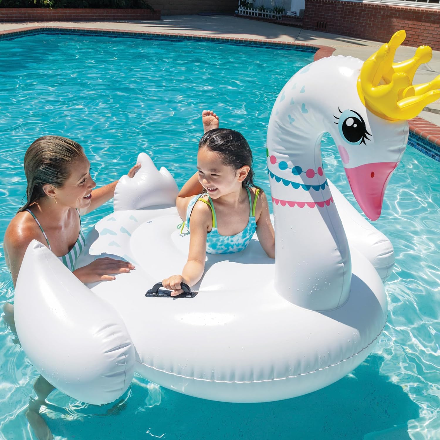 Eine Frau und ein Kind in einem Pool mit einem Schwan-Schwimmreifen.