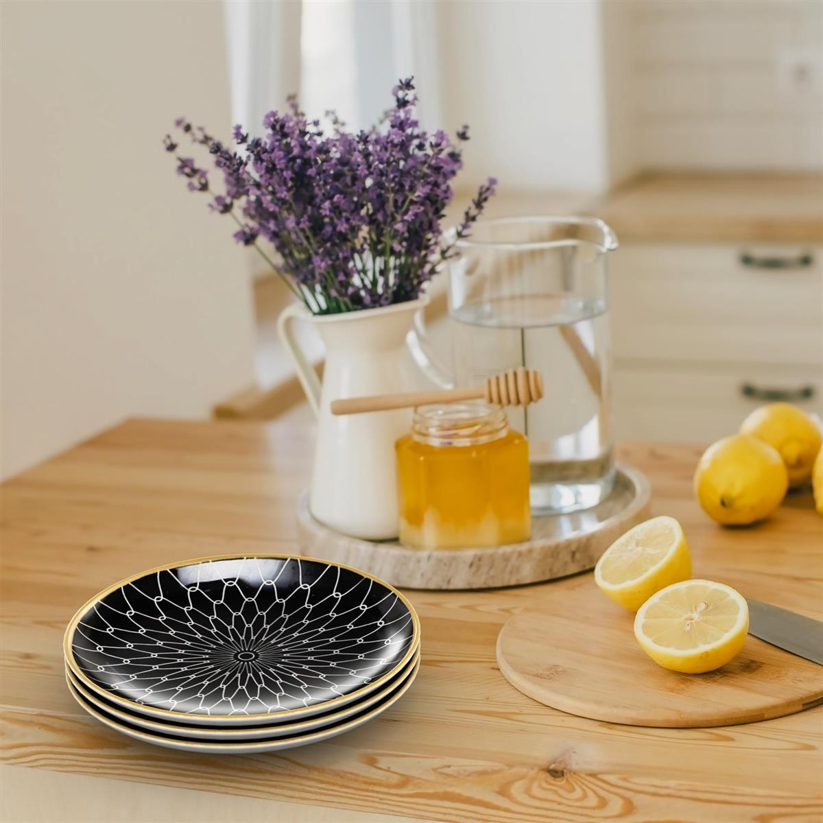 Ein Tisch mit Tellern, Blumen, Honig und Zitronenspalten, in einer hellen, gut beleuchteten Küche.