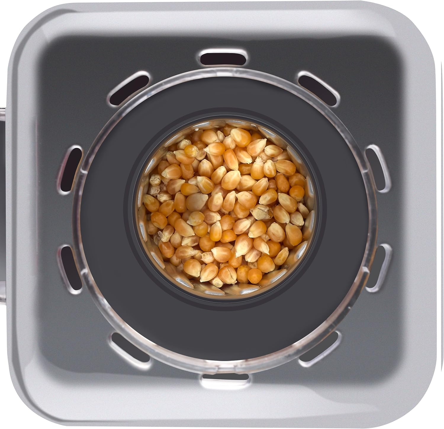 Popcornmais in einer Popcornmaschine. Grauer Hintergrund.