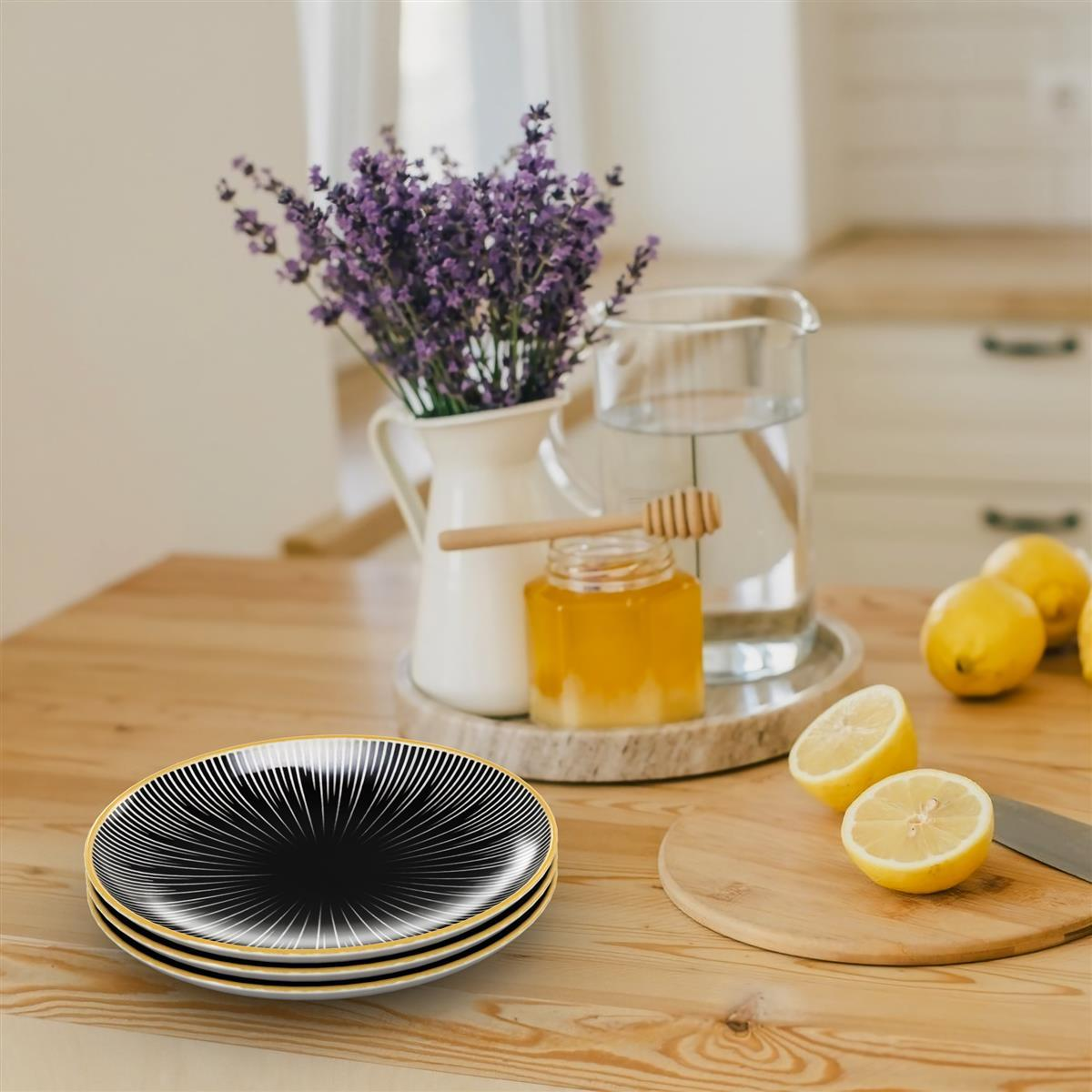Tischgedeck mit Tellern, einer Blumenvase, Zitronen und einem Honigglas.