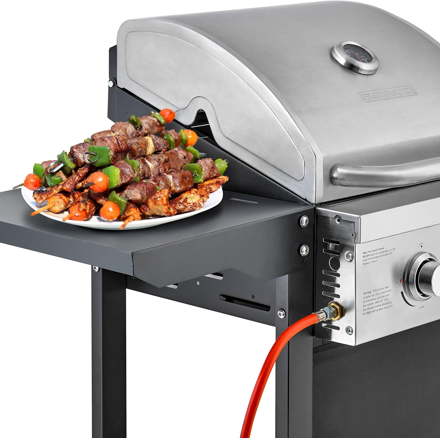 Gasgrill mit Spießen auf dem Beistelltisch. Rote Gasleitung. Edelstahl und Schwarz.