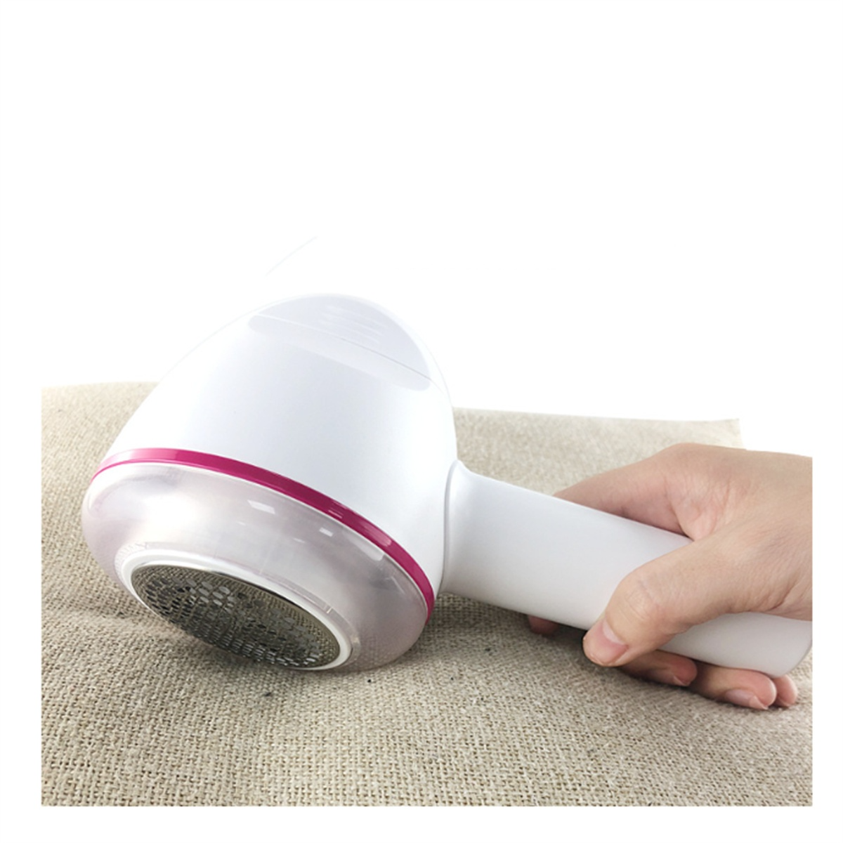 Hand hält einen weißen und rosa Stoffrasierer auf einer beigefarbenen Stoffoberfläche.
