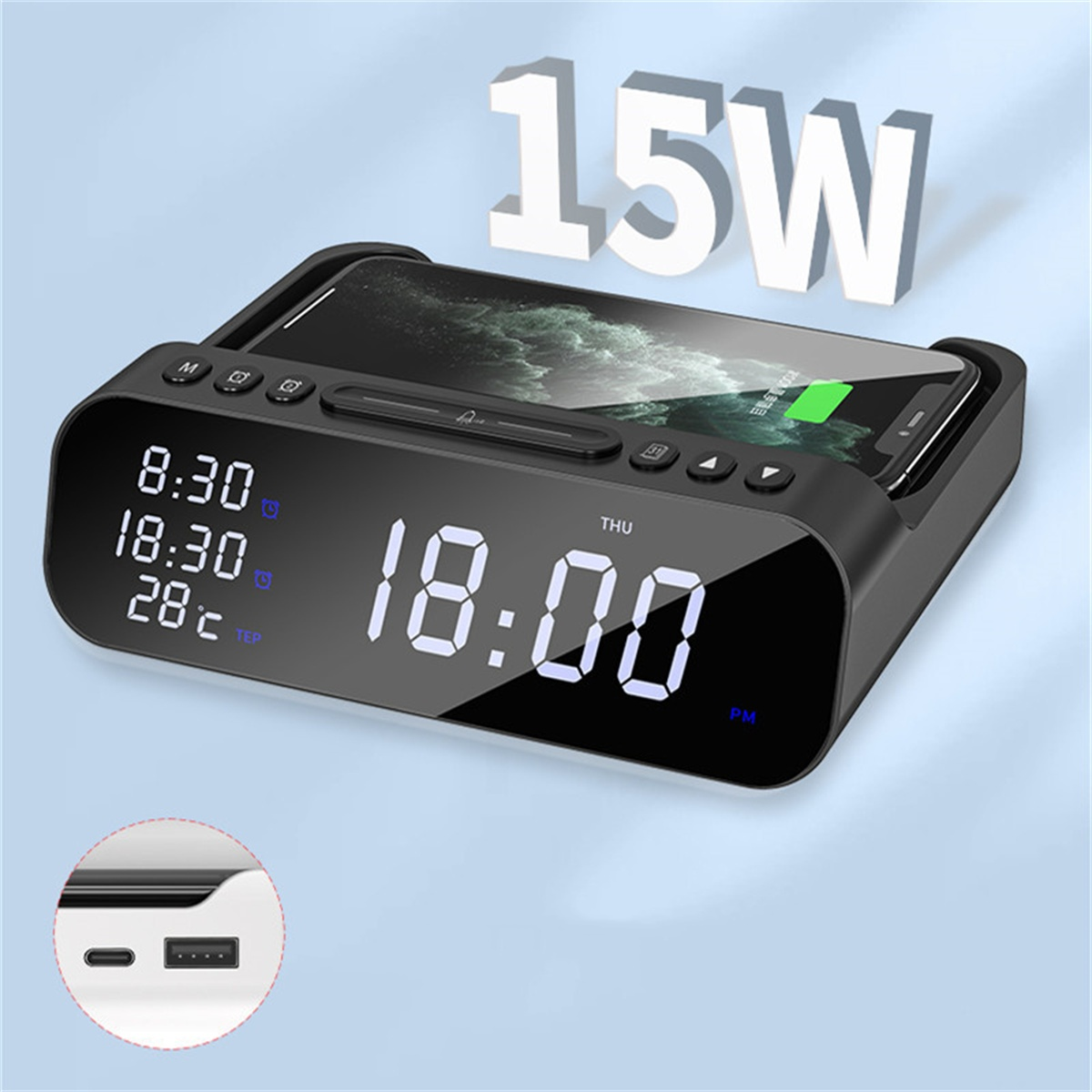 Schwarzer kabelloser Wecker mit Zeitanzeige. Ein Telefon liegt oben auf.