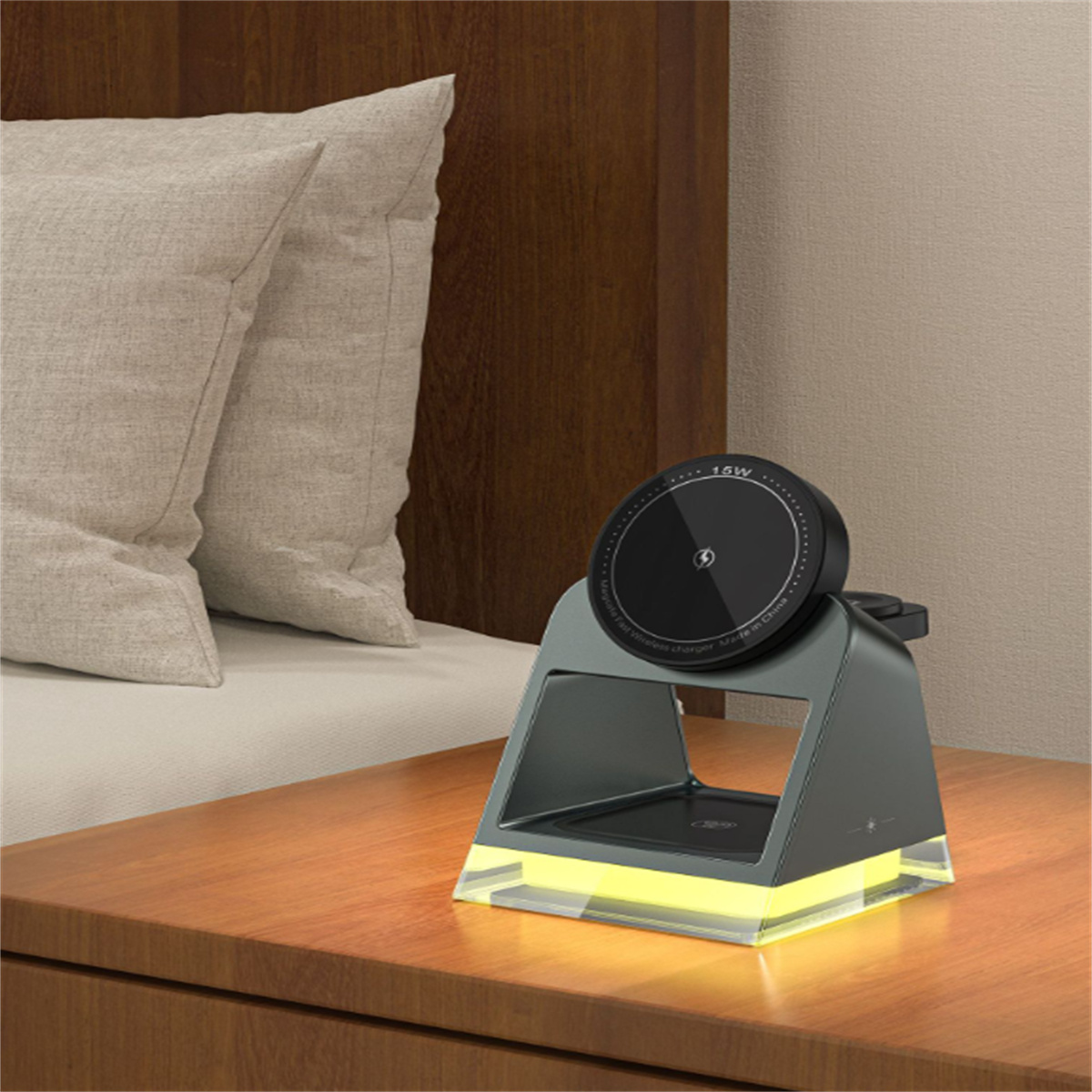 Eine moderne Ladestation mit einem Telefon darauf, neben einem Bett und Kissen.