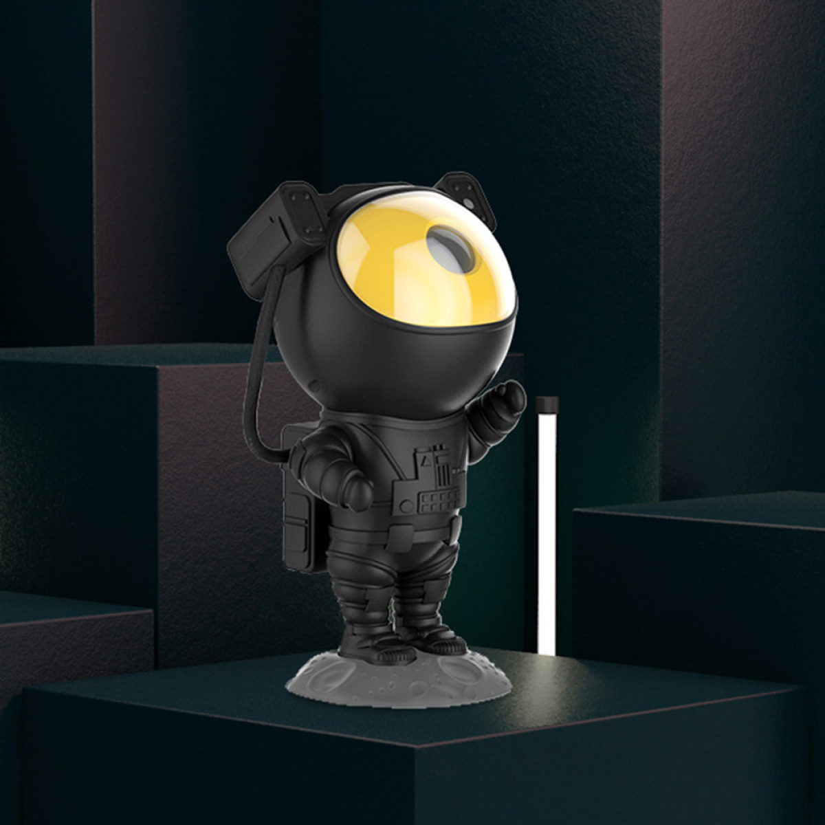 Schwarze Astronauten-Lampe mit gelbem Licht. Sie steht auf einer Oberfläche.