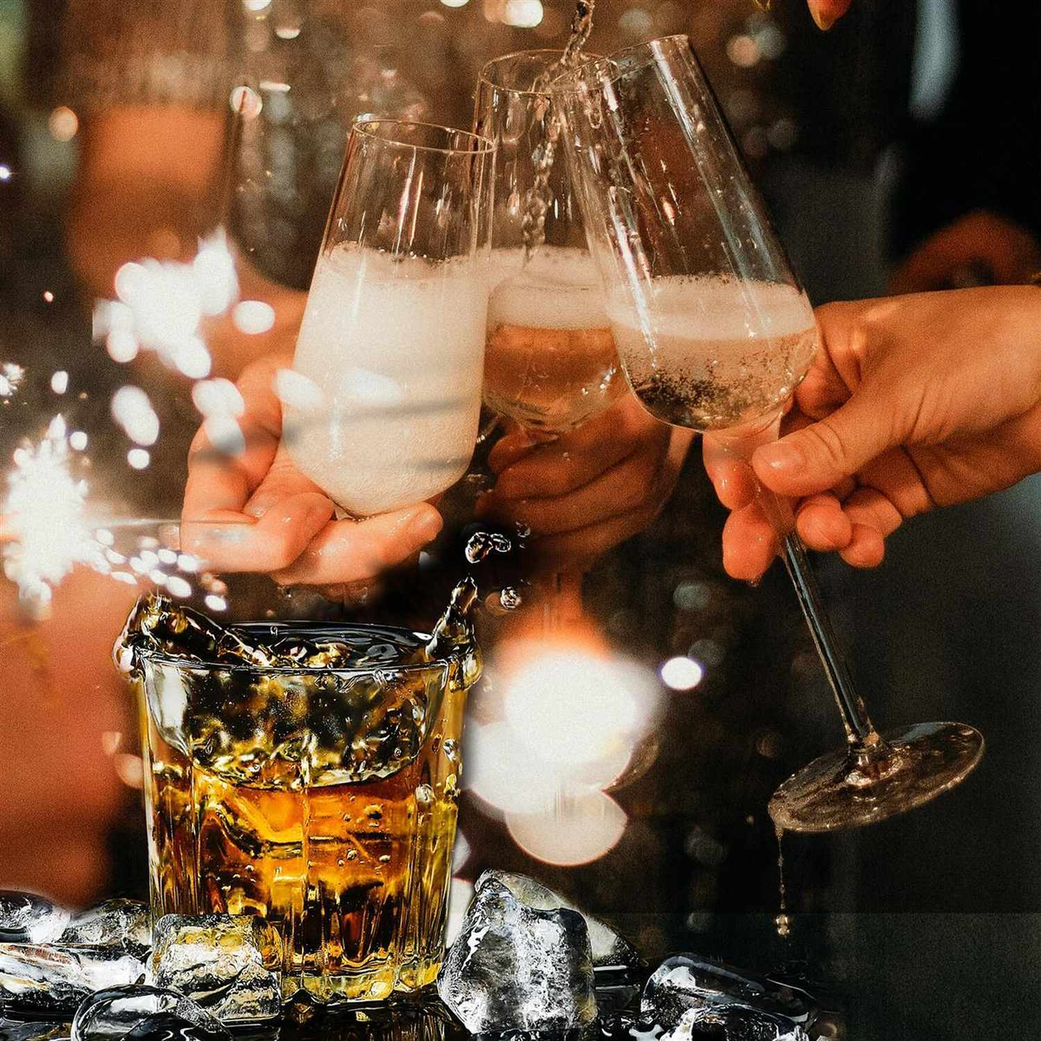 Personen stoßen mit Champagner und einem Cocktail mit Eiswürfeln an. Wunderkerzen im Hintergrund.