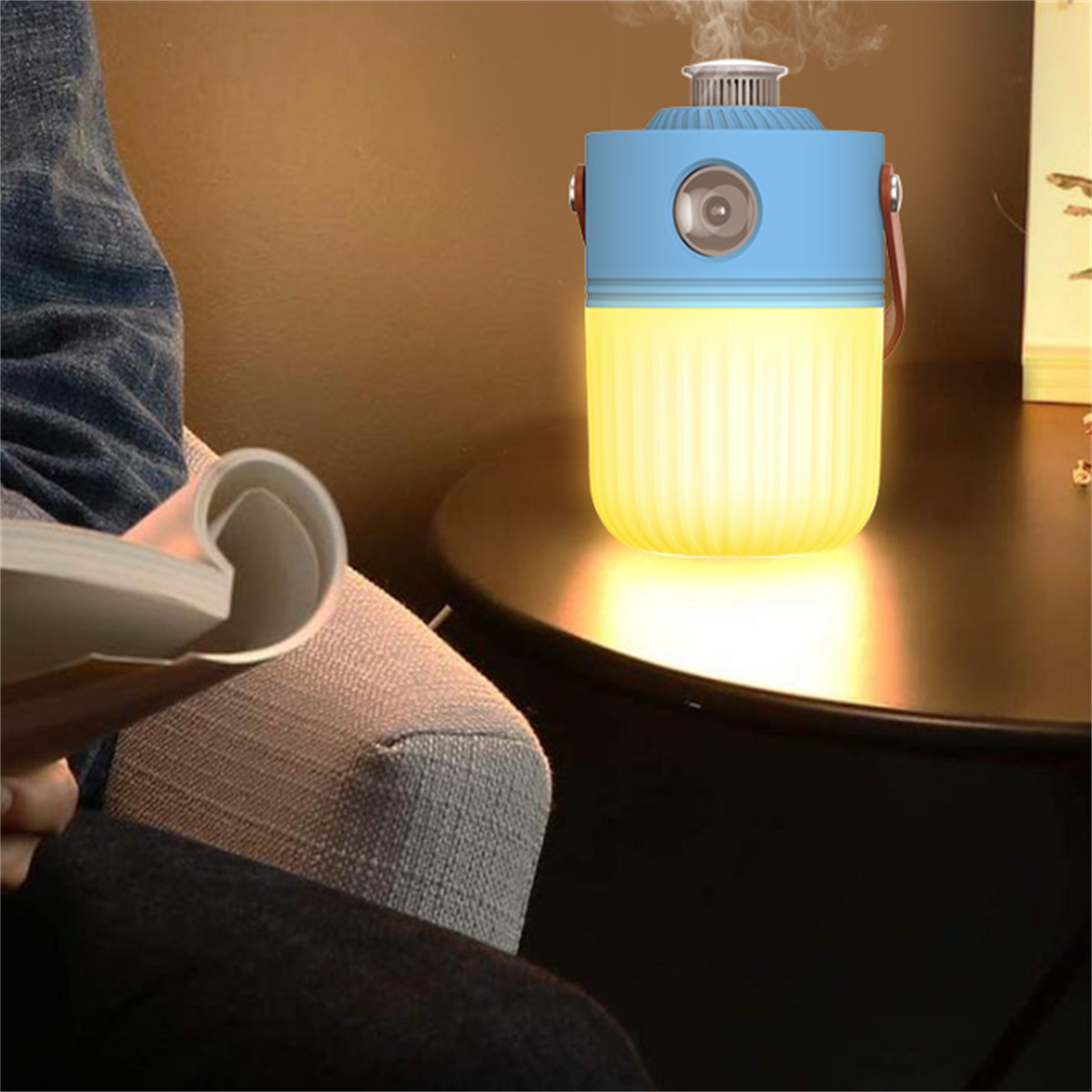 Ein blau-weißer Aromatherapie-Diffusor steht auf einem Tisch und emittiert Dampf. Eine Person liest.