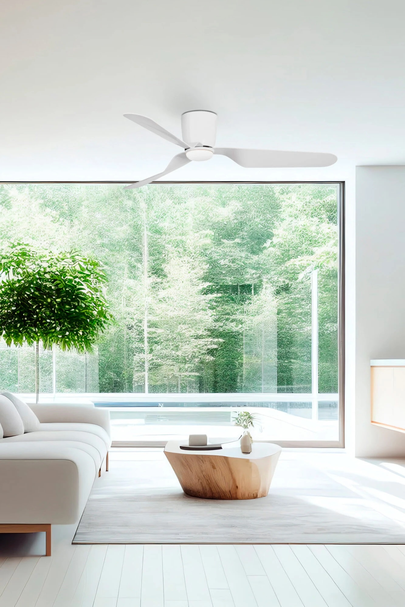 Ein modernes Wohnzimmer mit einem weißen Deckenventilator. Es gibt ein weißes Sofa, einen Baum und ein großes Fenster.