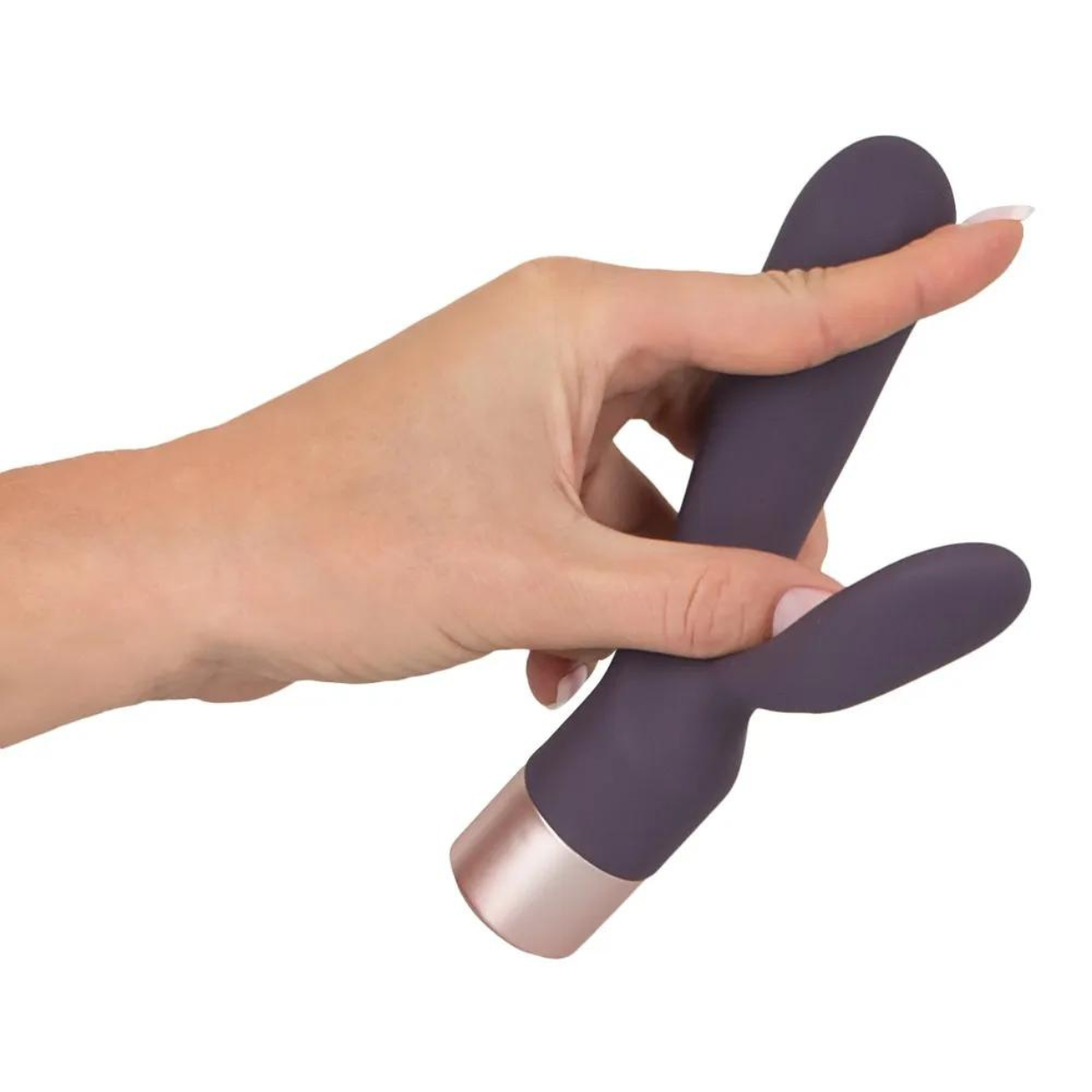 Hand hält ein lila Sexspielzeug mit roségoldener Spitze. Weißer Hintergrund.