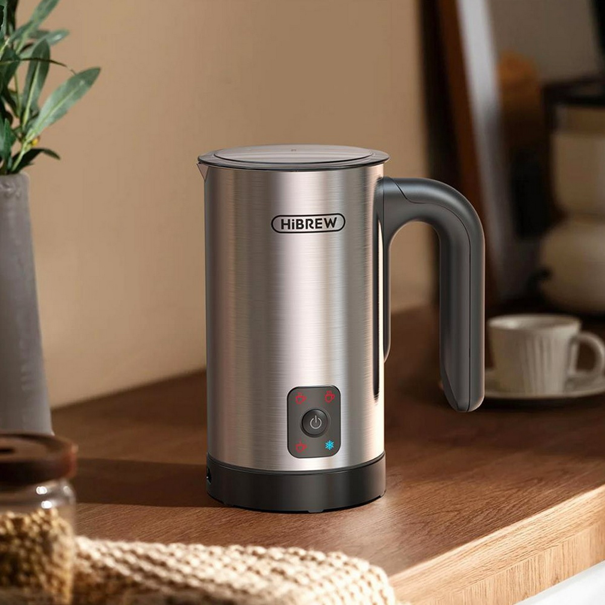 Srebrny spieniacz do mleka na drewnianej powierzchni.