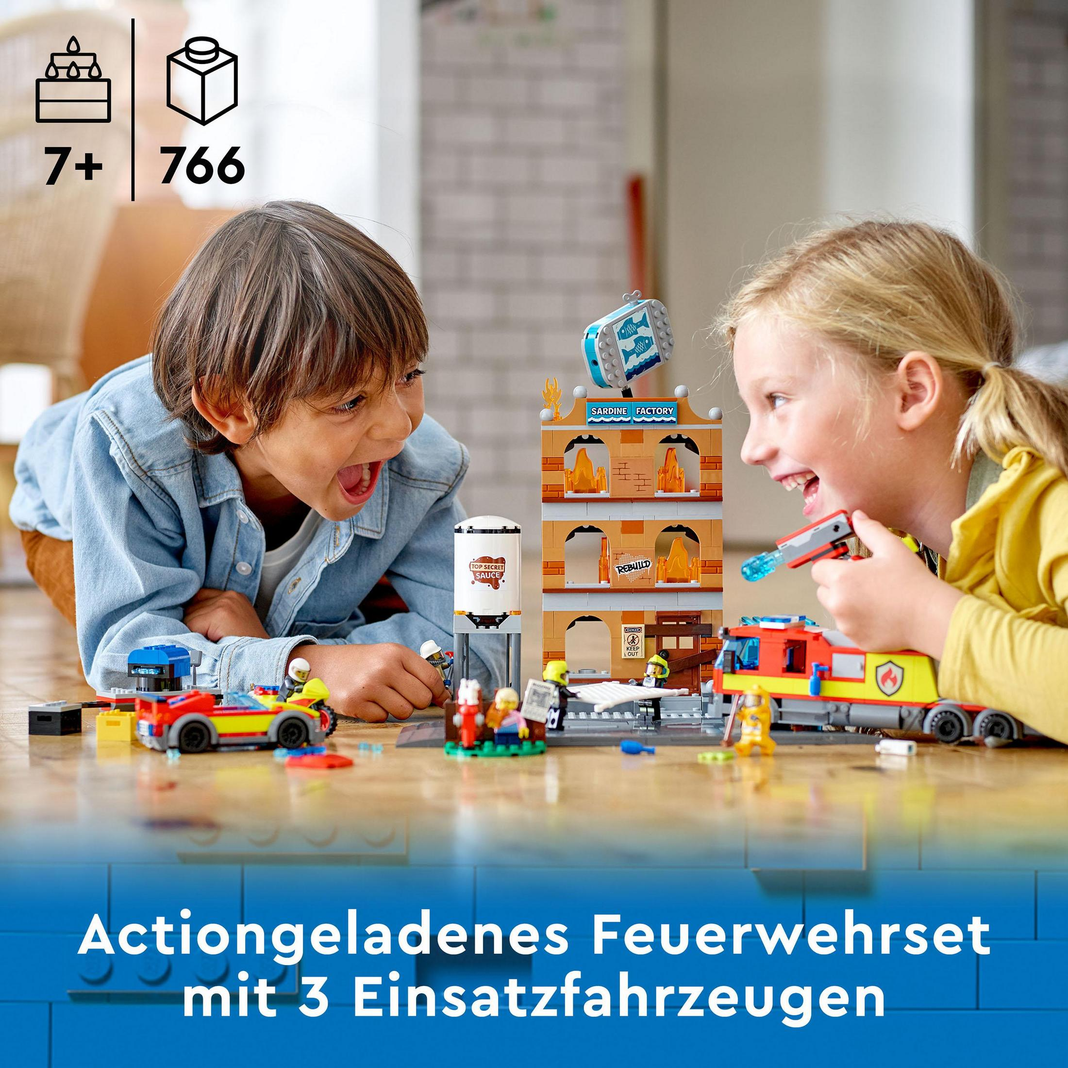 Deux enfants jouant avec un jeu Lego d'une caserne de pompiers.