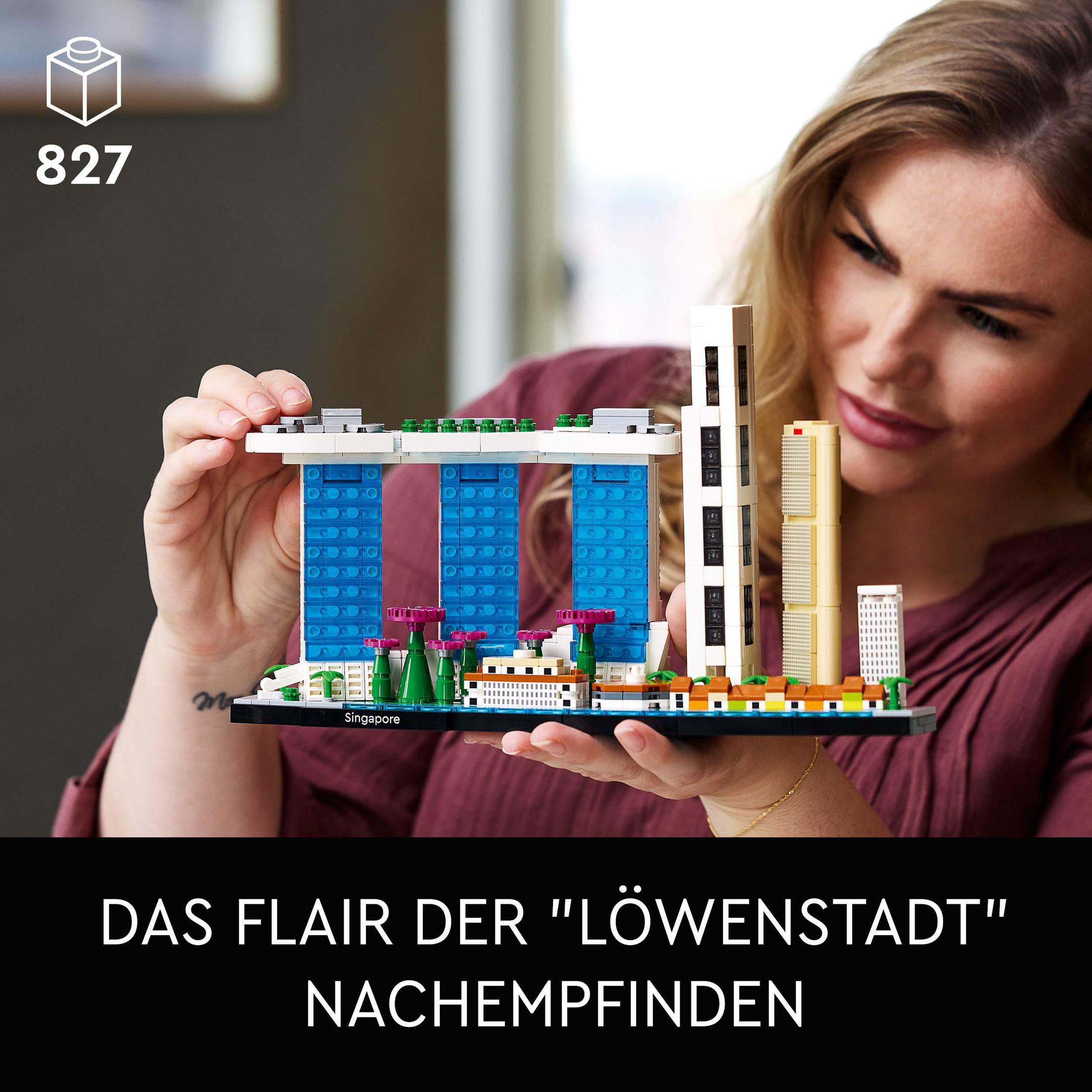 Een vrouw die een Lego-set van het Marina Bay Sands-gebouw in Singapore vasthoudt. Tekst in het Duits.