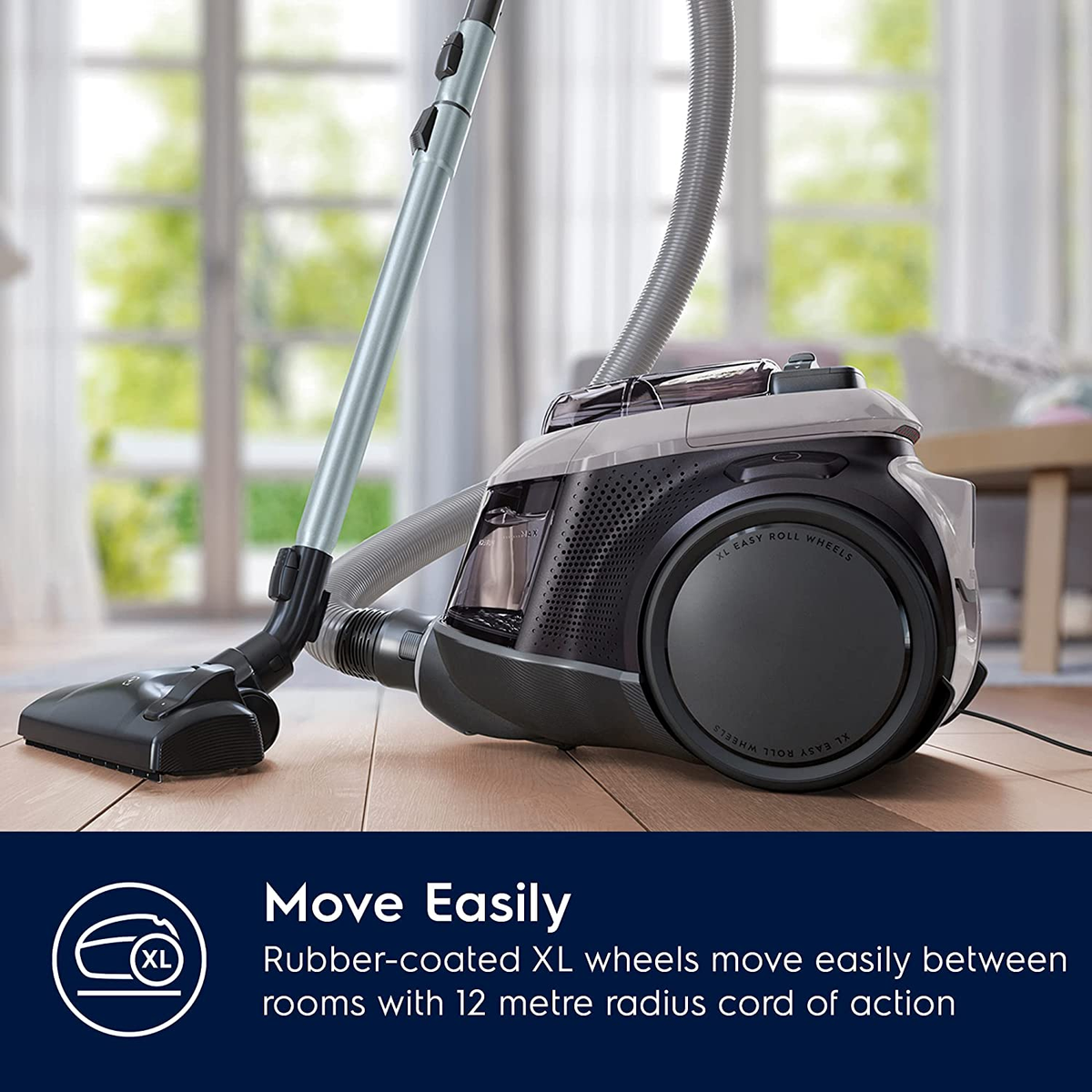 Odkurzacz na drewnianej podłodze z tekstem 'Move Easily' i 'XL wheels'.
