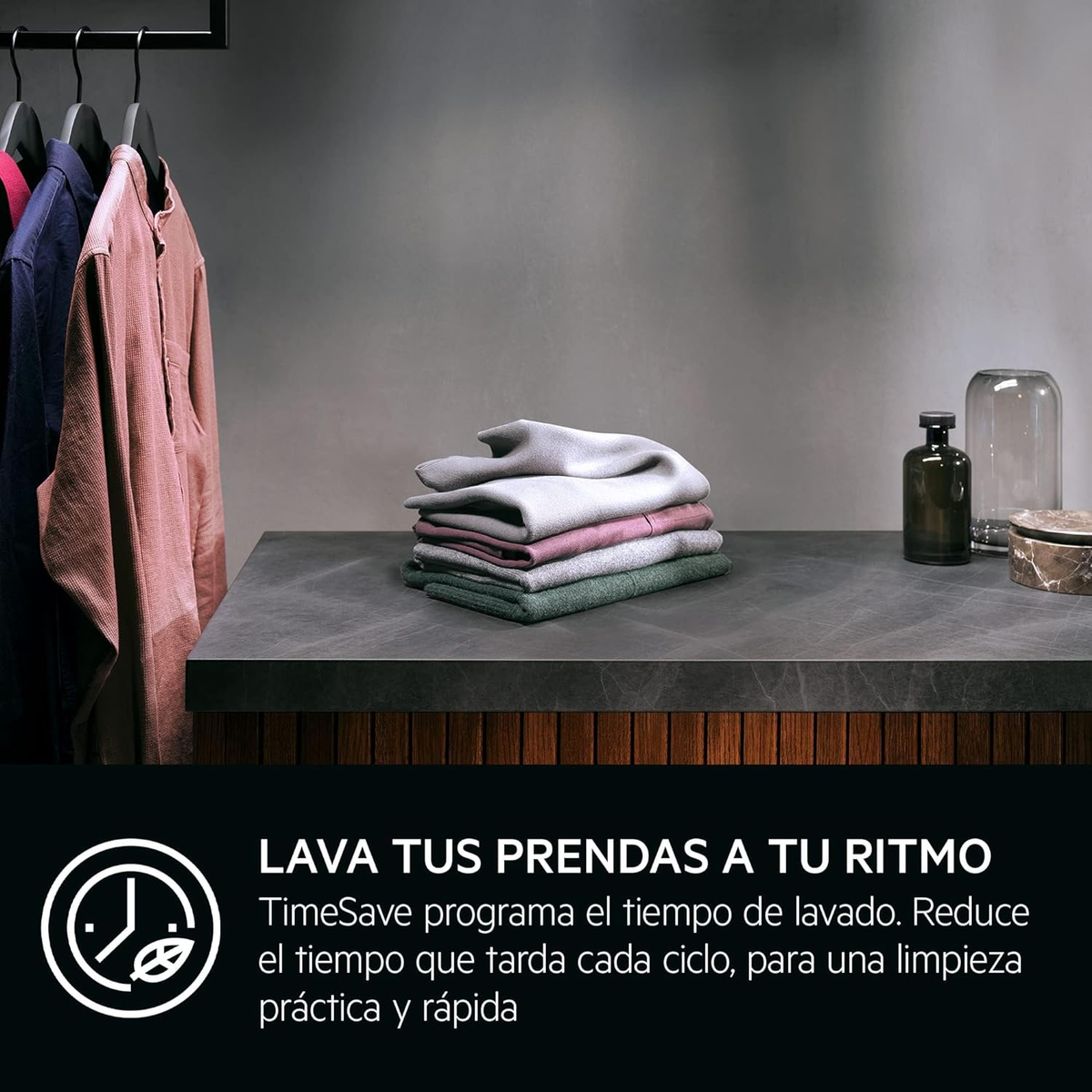 Ubrania wiszące na wieszaku, ze stosem złożonych ubrań na blacie i tekstem poniżej.