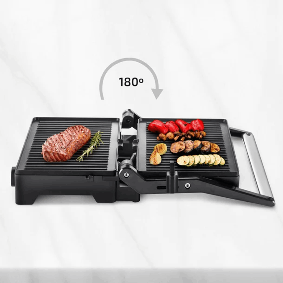 Ein offener Grill mit gekochtem Essen. Ein Steak, Gemüse und ein Rosmarinzweig sind sichtbar.