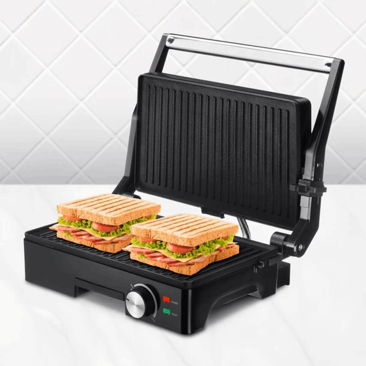 Eine Sandwichpresse mit zwei Sandwiches. Die Presse ist schwarz und steht auf einer weiß gefliesten Oberfläche.