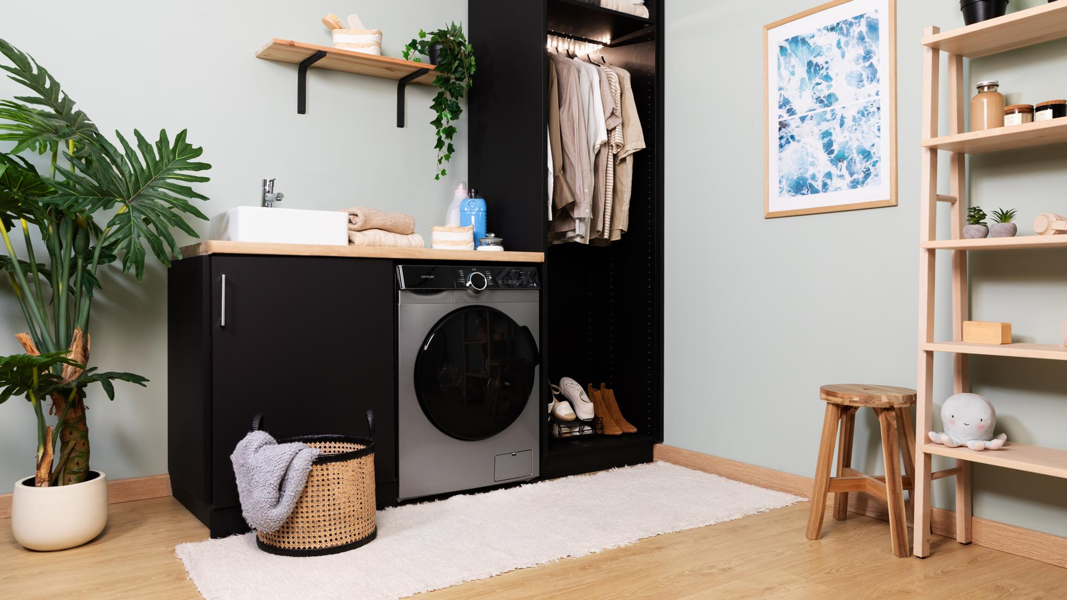 Pralnia z pralką, koszem, półką i oprawioną sztuką. Czarne szafki i biały dywan.