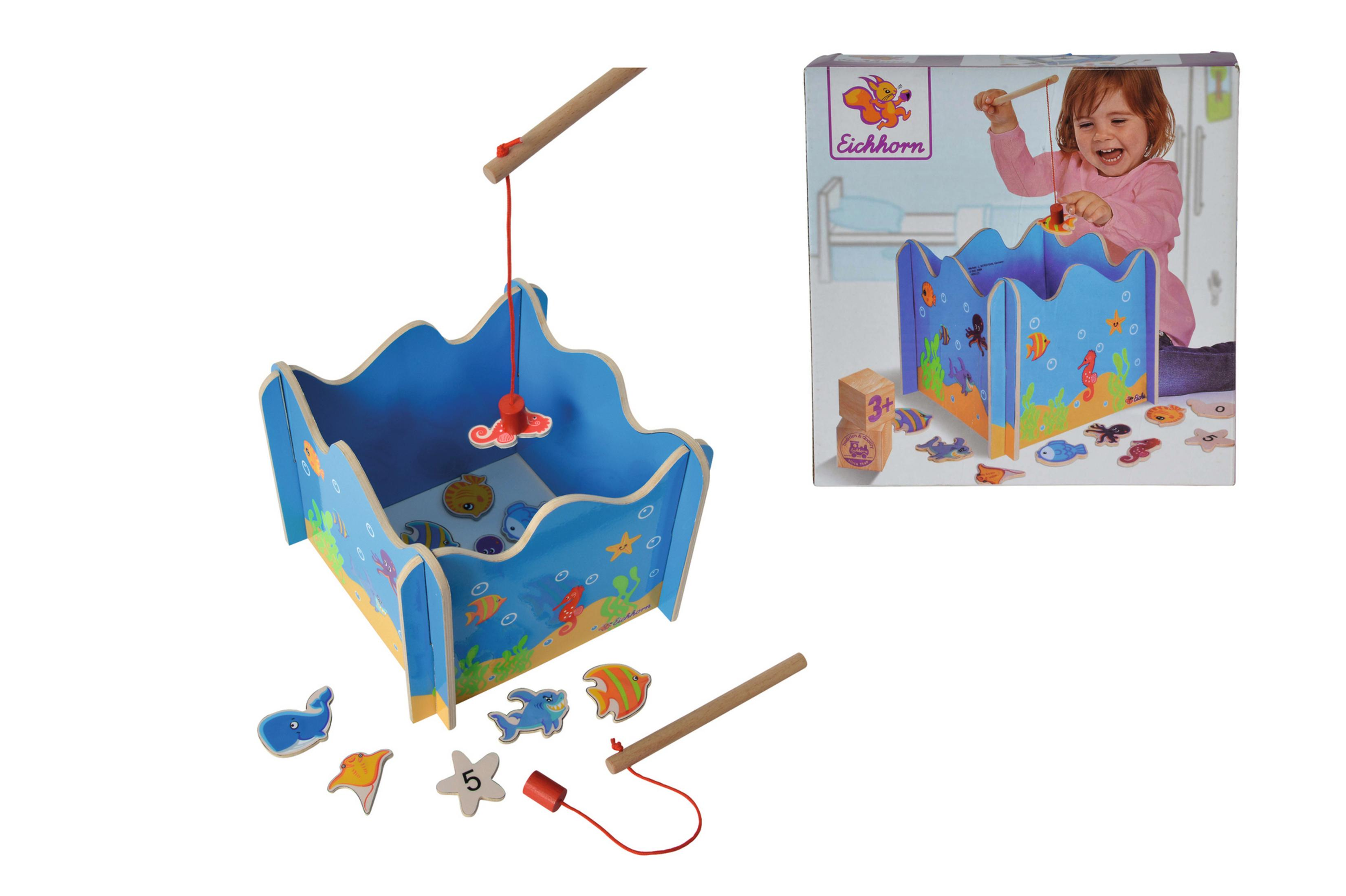 Ein Angelspielzeug aus Holz mit Fischen und einer Angelrute. Im Hintergrund spielt ein Kind in der Box.