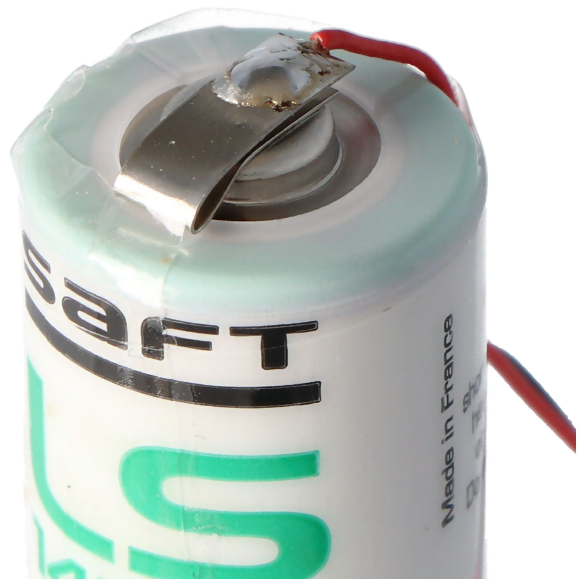 Nahaufnahme einer kleinen, zylindrischen Batteriezelle mit Metallclip und rotem Draht.