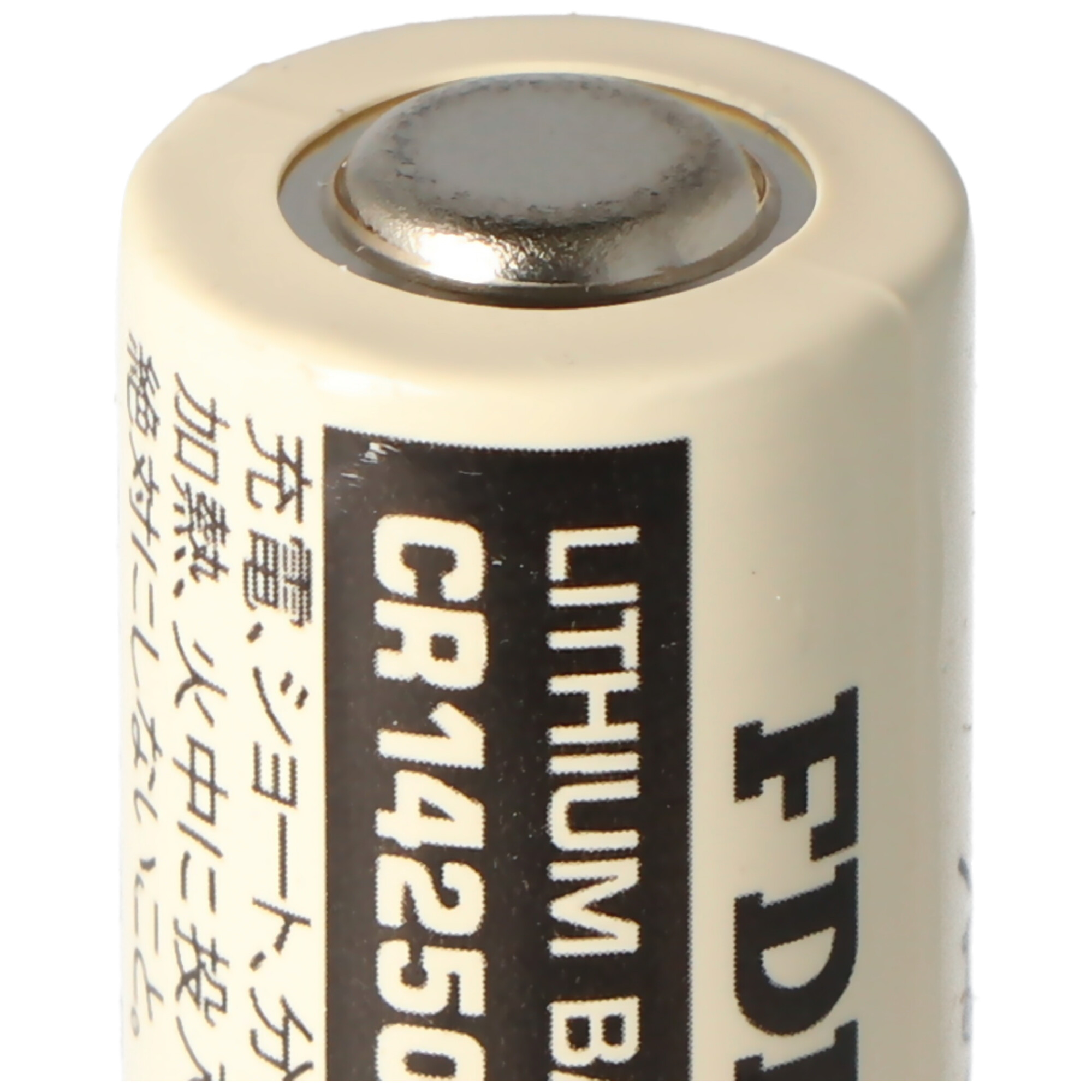 Nahaufnahme einer zylindrischen Batterie mit Aufdruck und metallischer Oberseite. Sie ist cremefarben.
