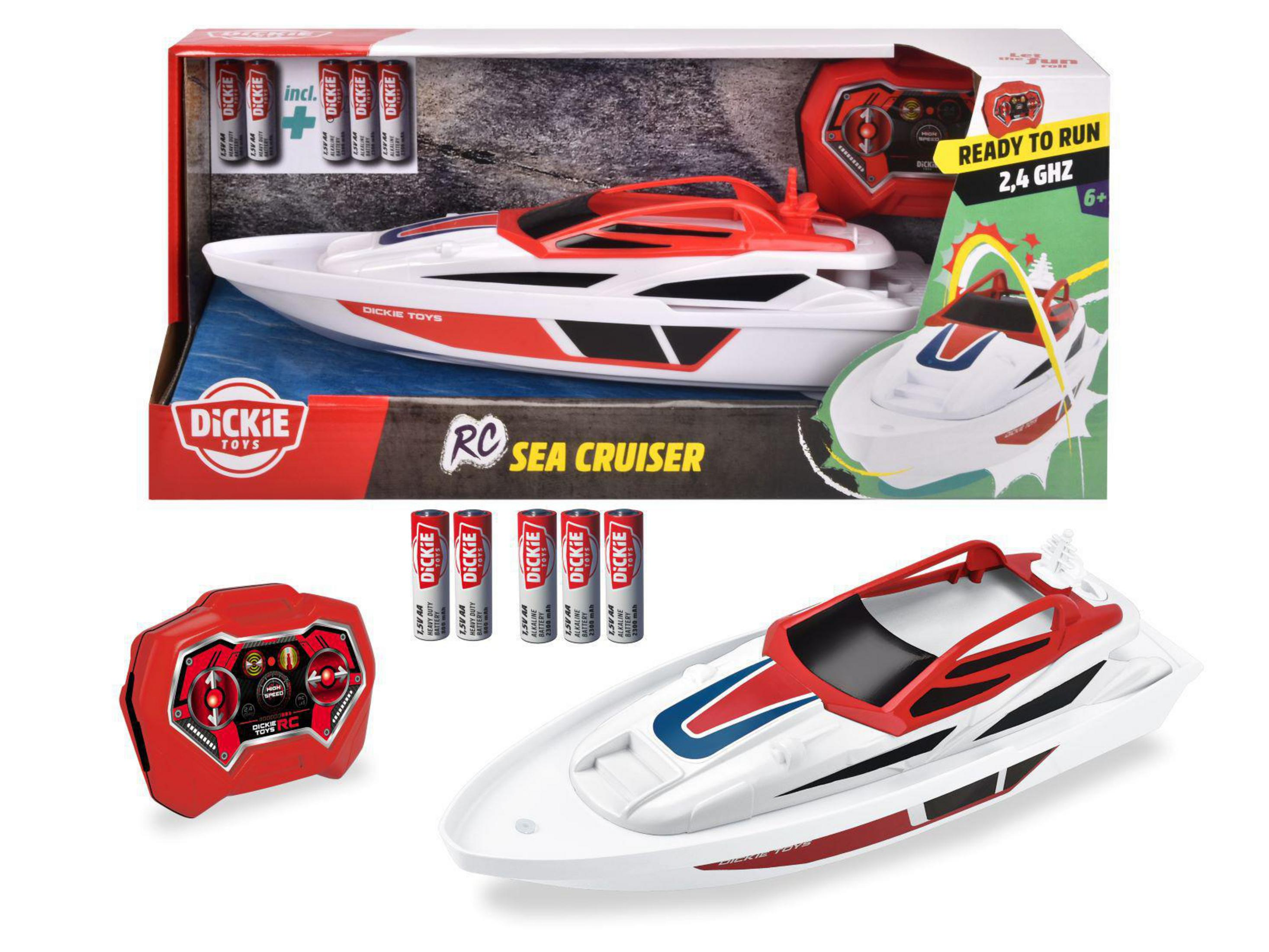 Un barco de juguete RC en una caja. El barco es blanco y rojo, con mando a distancia y pilas.