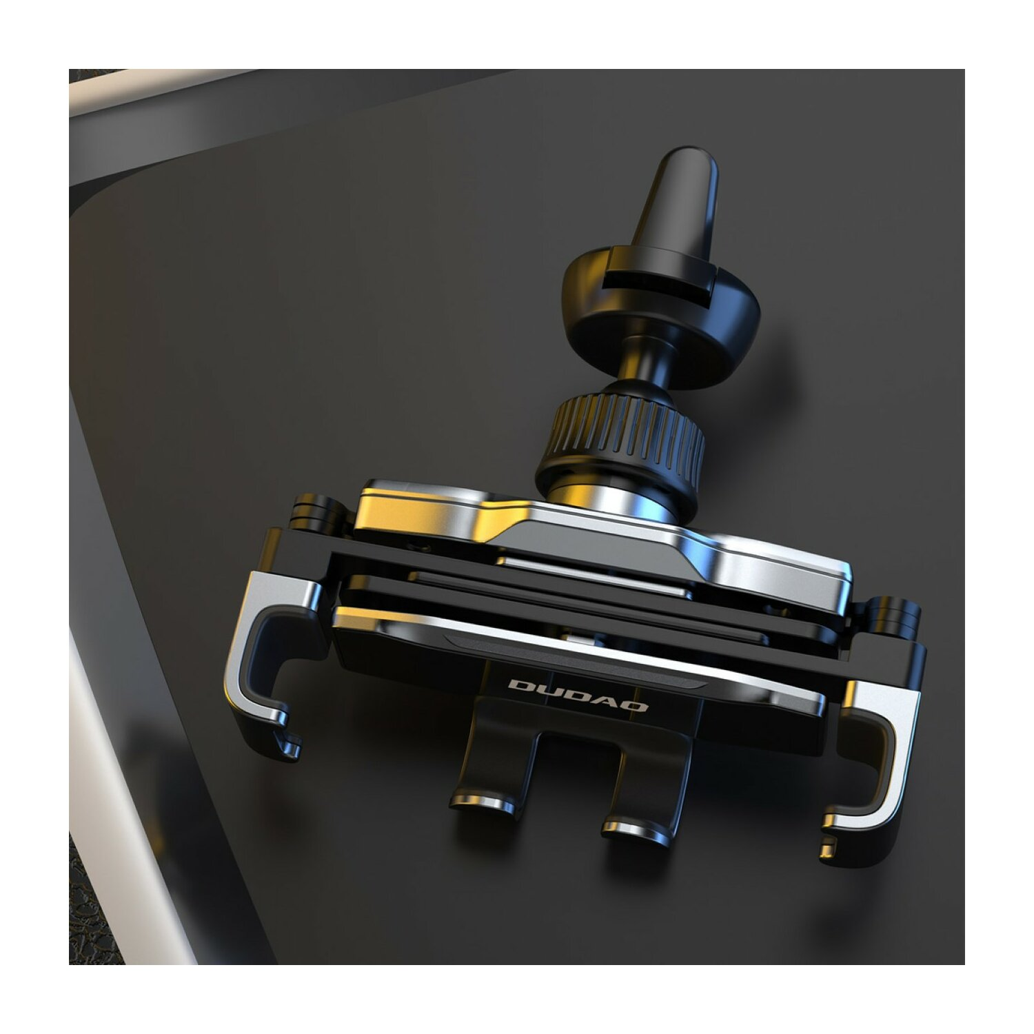 Czarny i srebrny uchwyt samochodowy na telefon na ciemnej powierzchni.