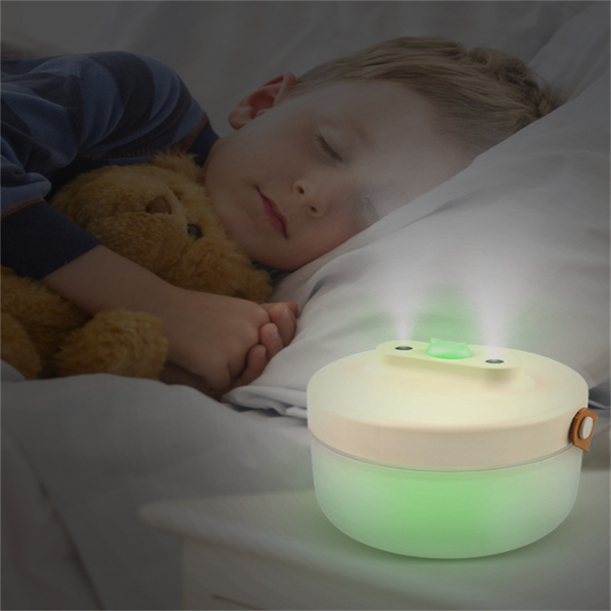 Ein kleiner Junge, der neben einem Luftbefeuchter schläft. Der Luftbefeuchter leuchtet grün und weiß.