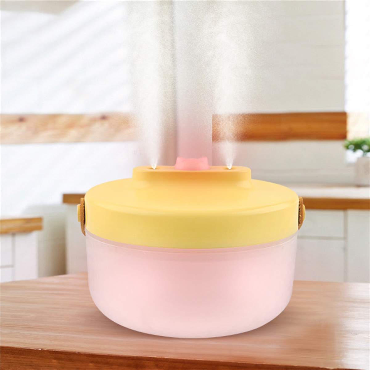Ein rosa und gelber Luftbefeuchter, der Wasser sprüht. Er steht auf einem Holztisch in einer Küche.
