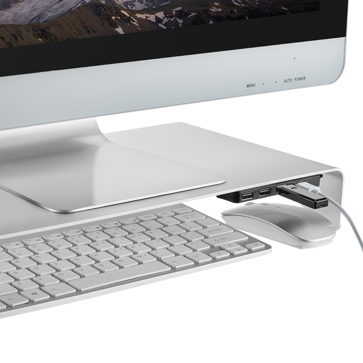 Ein Computermonitor steht auf einem Ständer. Eine Tastatur, Maus und USB-Kabel sind sichtbar.