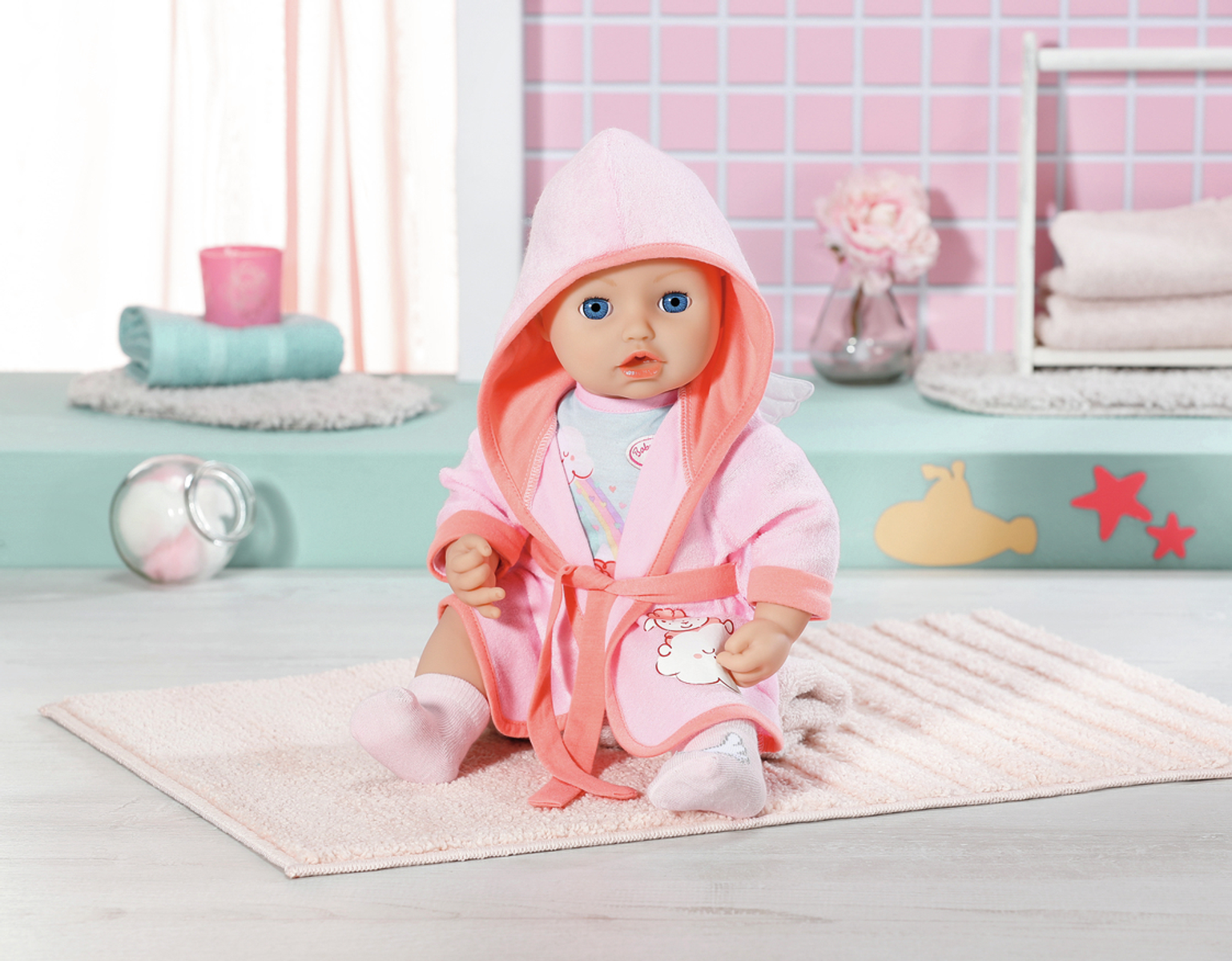 Babypuppe in rosa Bademantel, sitzt auf einem Handtuch. Hintergrund hat eine rosa Wand und Dekorationen.