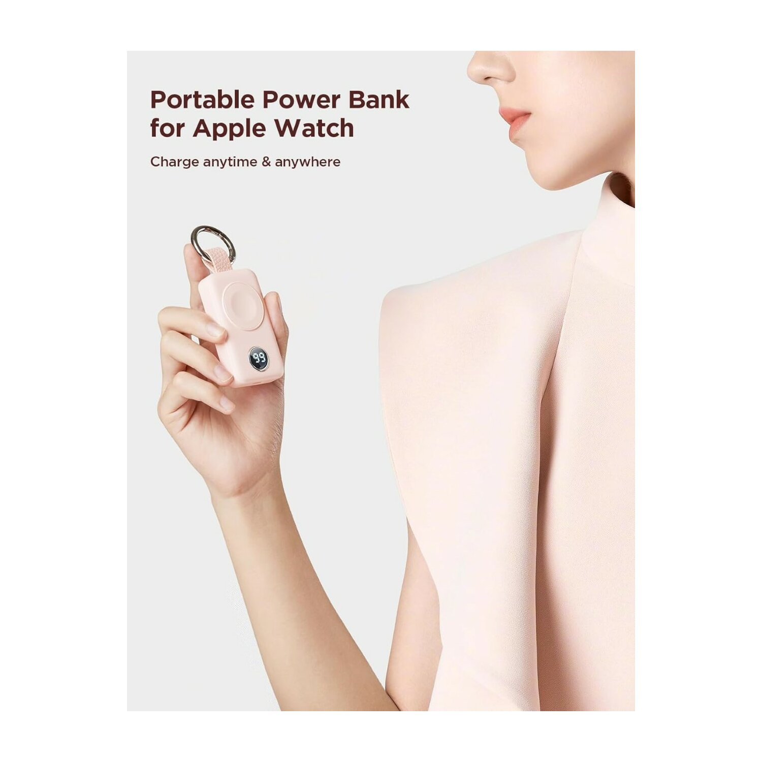 Mujer sosteniendo un banco de energía portátil rosa para un Apple Watch. Pantalla muestra 99%.