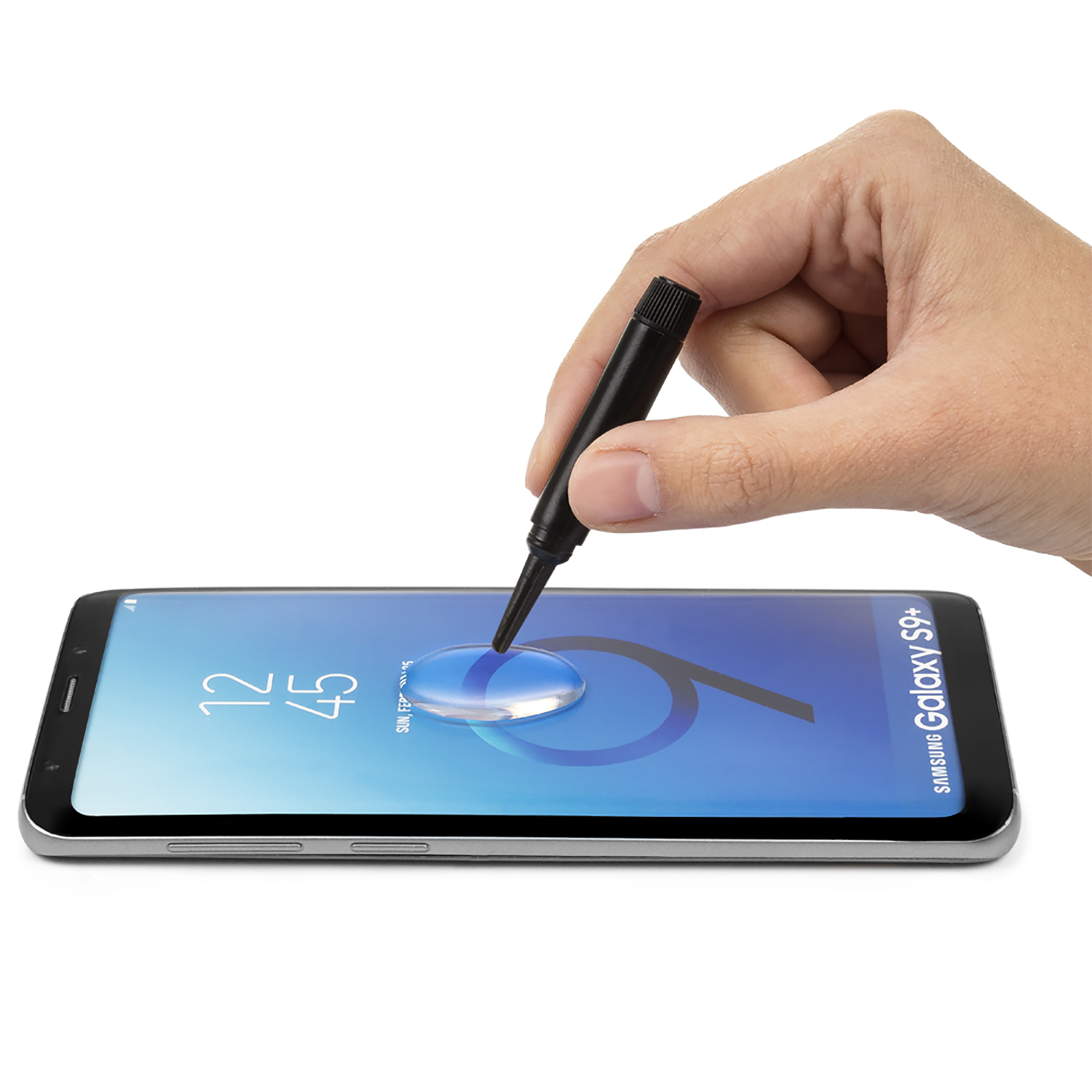 Una mano applica del liquido sullo schermo di un telefono. Un telefono Samsung Galaxy S9+ è visibile.