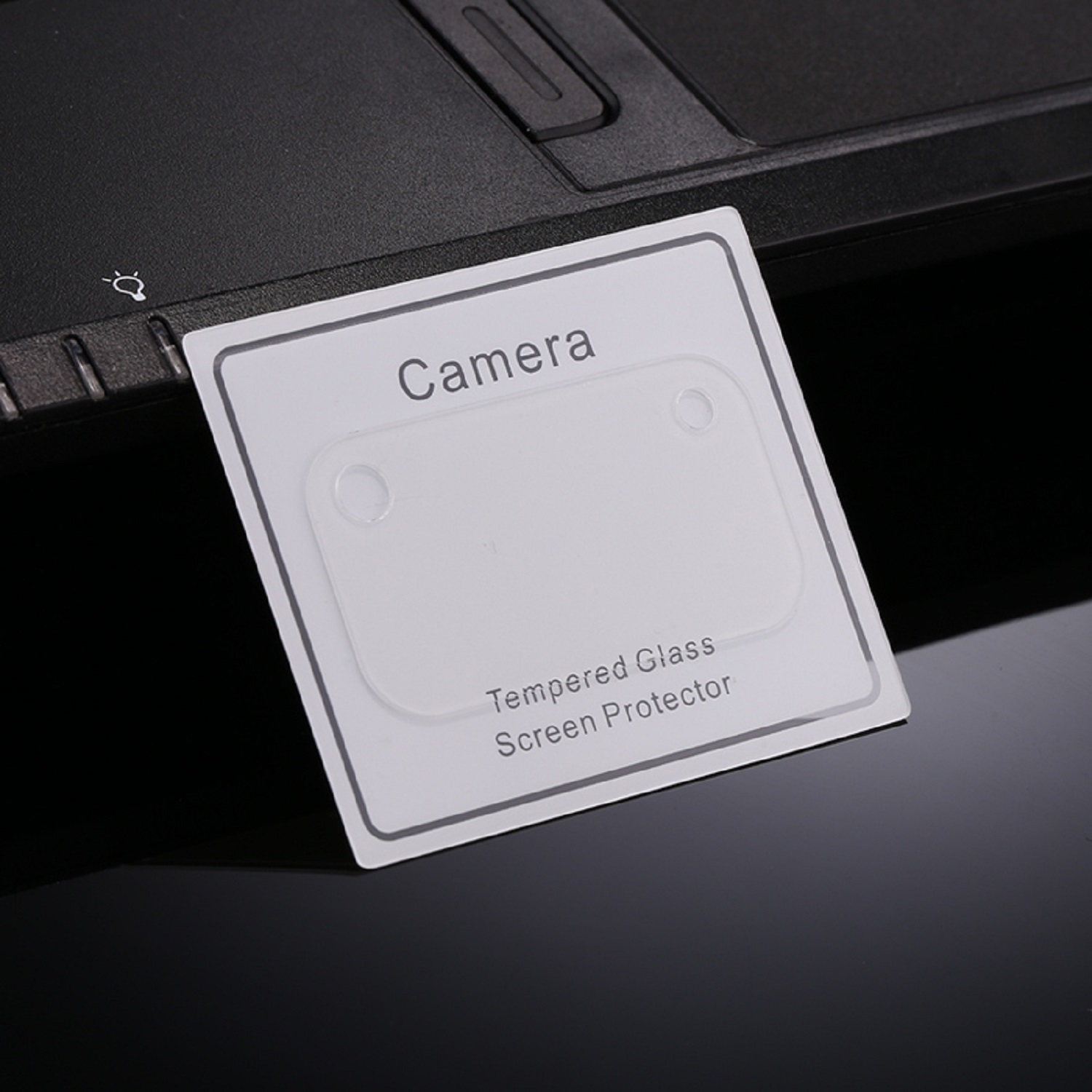 Weiße Karte mit 'Kamera'-Text und einem transparenten Displayschutz über einer Laptop-Tastatur.