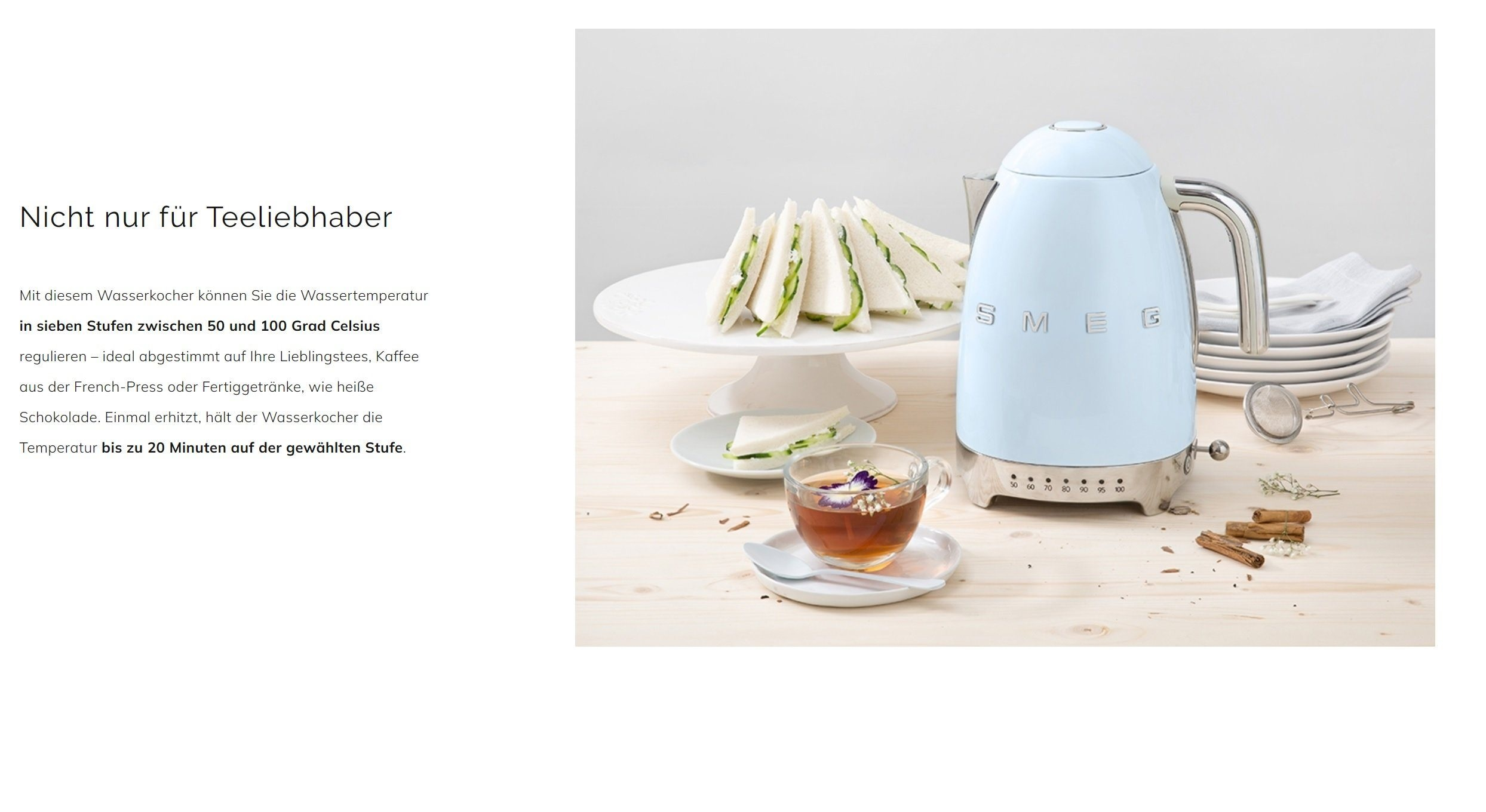 Ein hellblaues SMEG-Kessel, Sandwiches und Tee auf einem Holztisch. Text auf Deutsch ist sichtbar.
