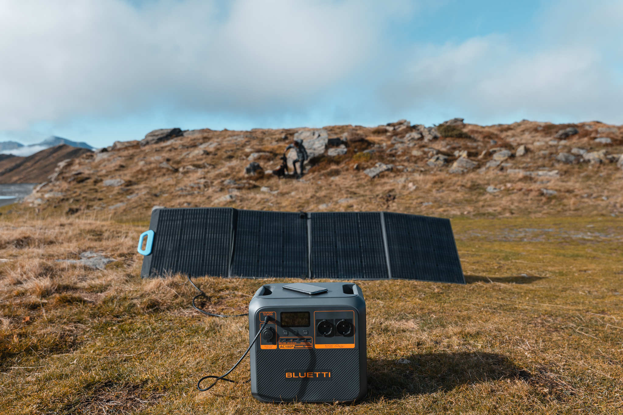 Przenośna stacja zasilania i panel słoneczny ustawione na trawiastym polu.