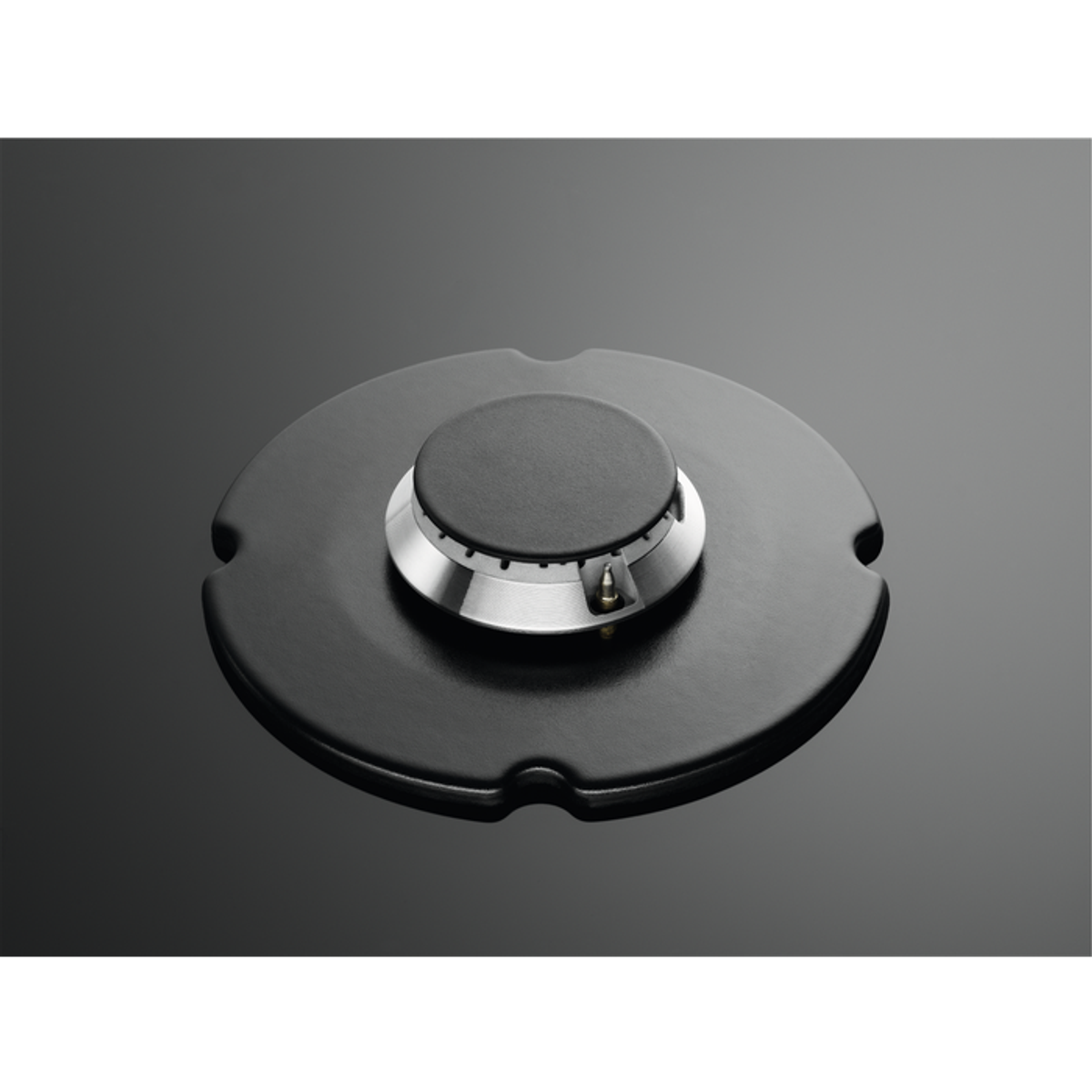 Bruciatore nero con anello metallico e sfondo nero.