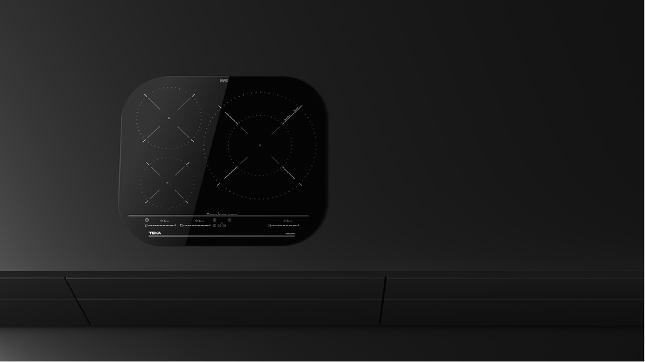 Czarna płyta indukcyjna na czarnej powierzchni. Cztery strefy gotowania z białymi oznaczeniami.