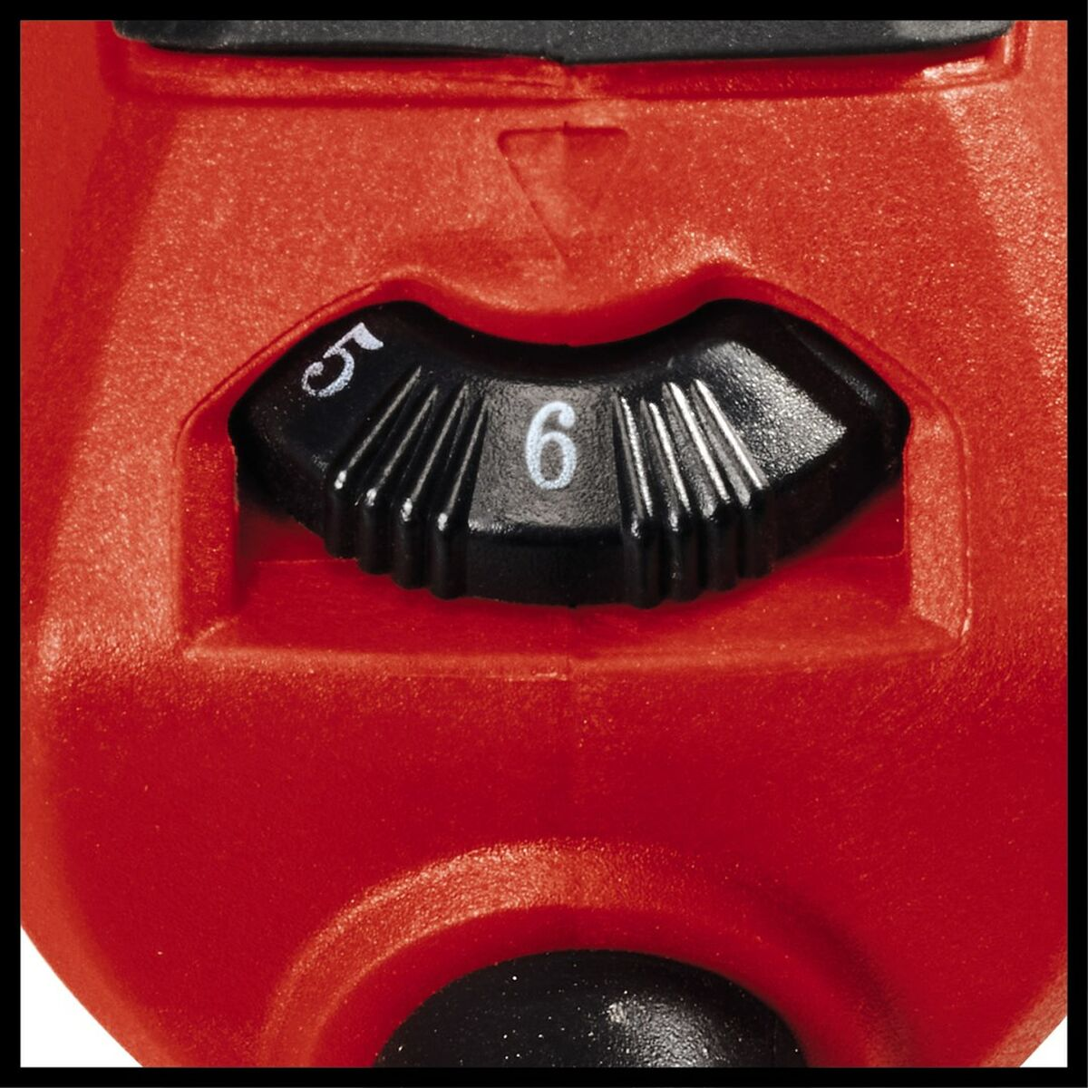 Zbliżenie na czerwone pokrętło narzędzia elektrycznego z cyframi 5 i 6 oraz strzałką. Pokrętło jest czarne.