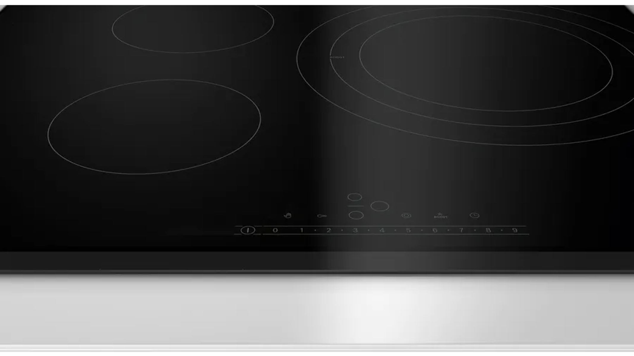Cocina de inducción negra con cuatro quemadores. La cocina es negra con marco plateado.