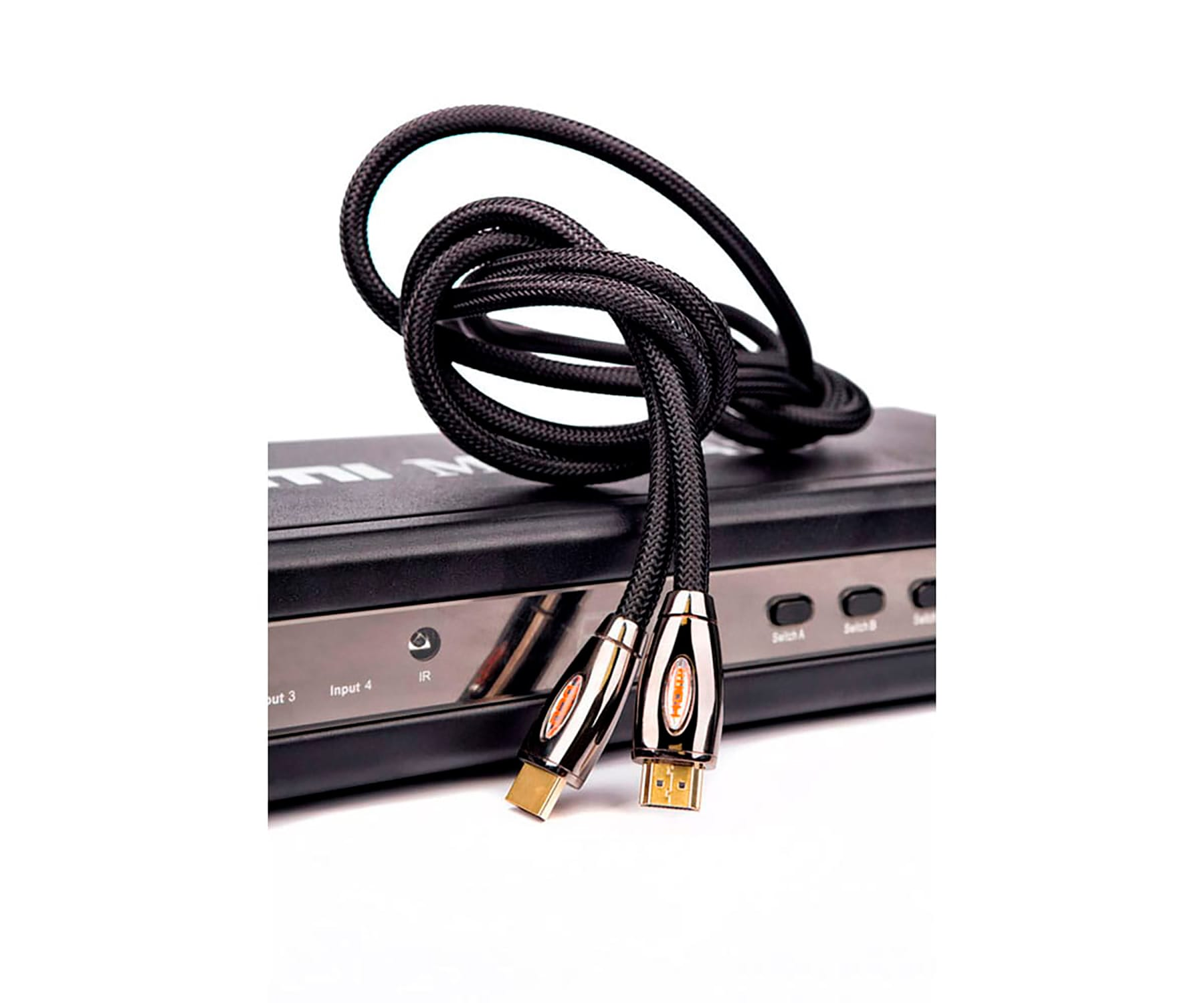 Cable HDMI negro con conectores dorados, conectado a un conmutador HDMI negro.
