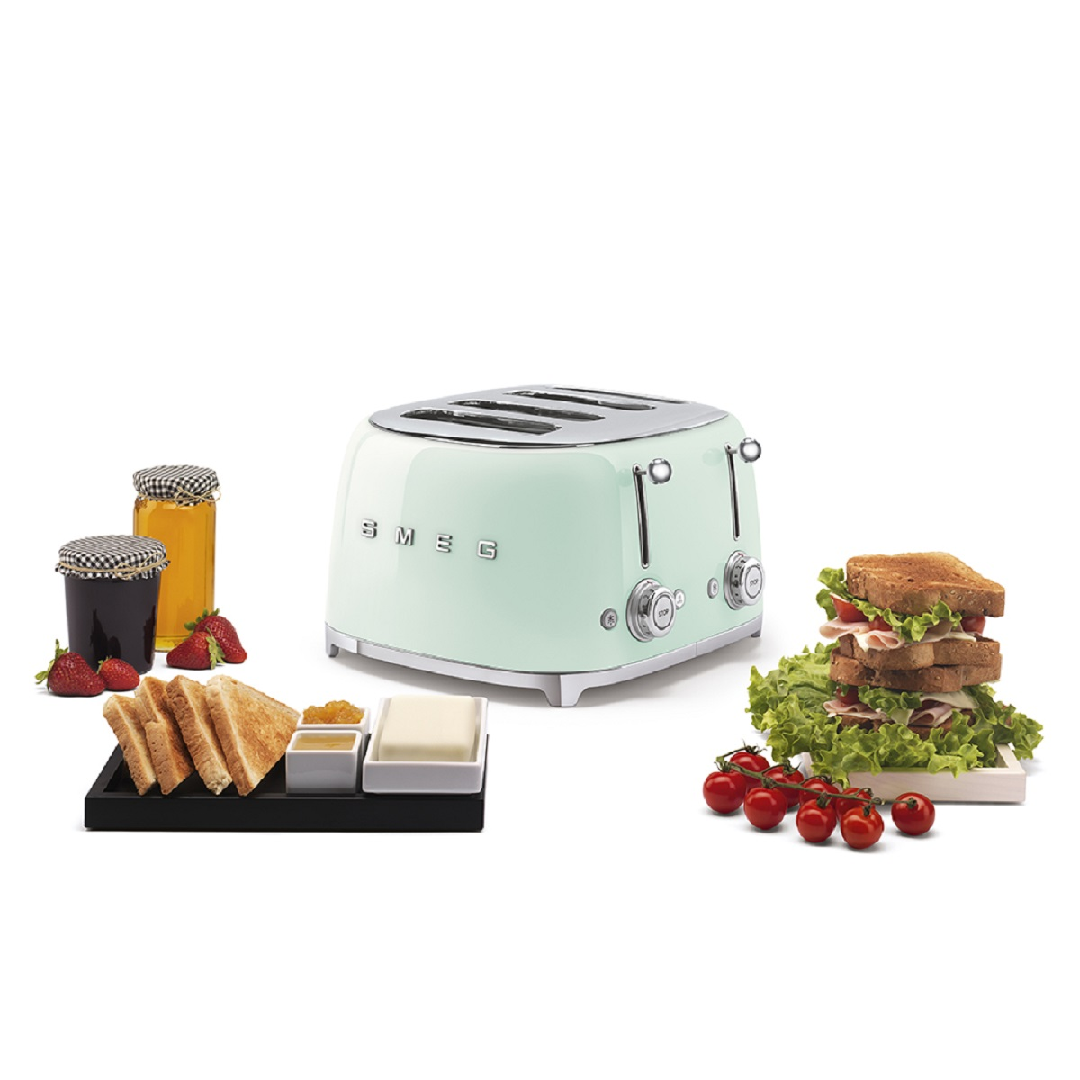 Ein mintgrüner Toaster im Retro-Stil mit Lebensmitteln. Das Essen beinhaltet Brot, Marmelade und Tomaten.