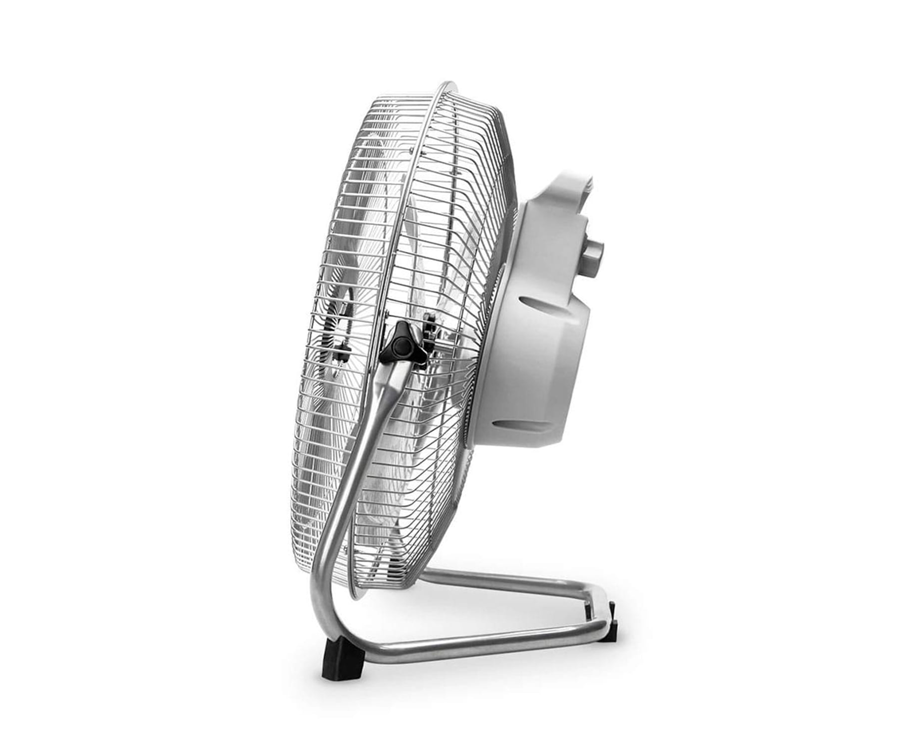 Ventilador plateado sobre un soporte. Tiene una jaula metálica. Fondo blanco.