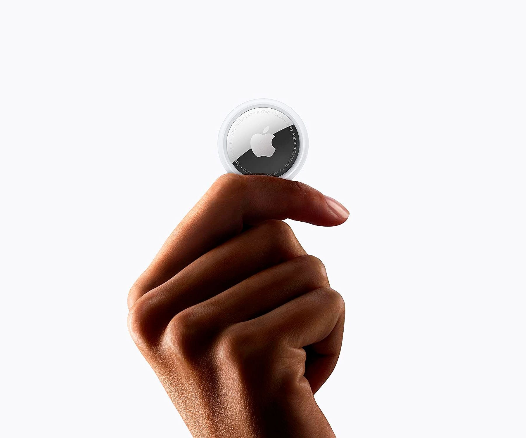Dłoń trzyma biały Apple AirTag. Logo jest widoczne.