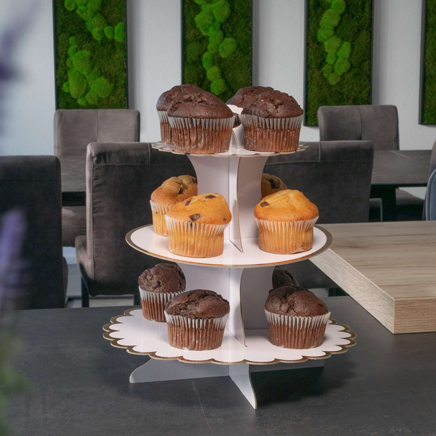 Ein dreistöckiger Cupcake-Ständer mit Schokoladen- und gelben Cupcakes.