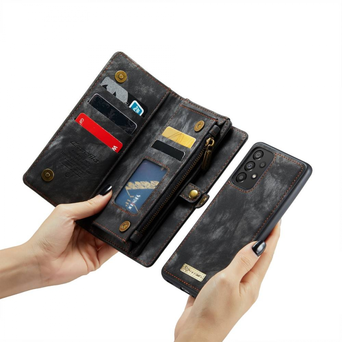 Hände halten offene dunkelgraue Brieftasche und Telefon. Karten, Bargeld und ein Reißverschluss sind sichtbar.