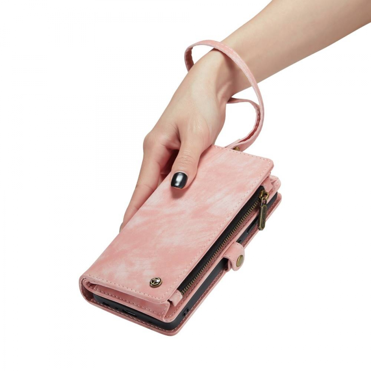 Die Hand einer Frau hält eine pinkfarbene Leder-Handyhülle mit Riemen und Reißverschluss.