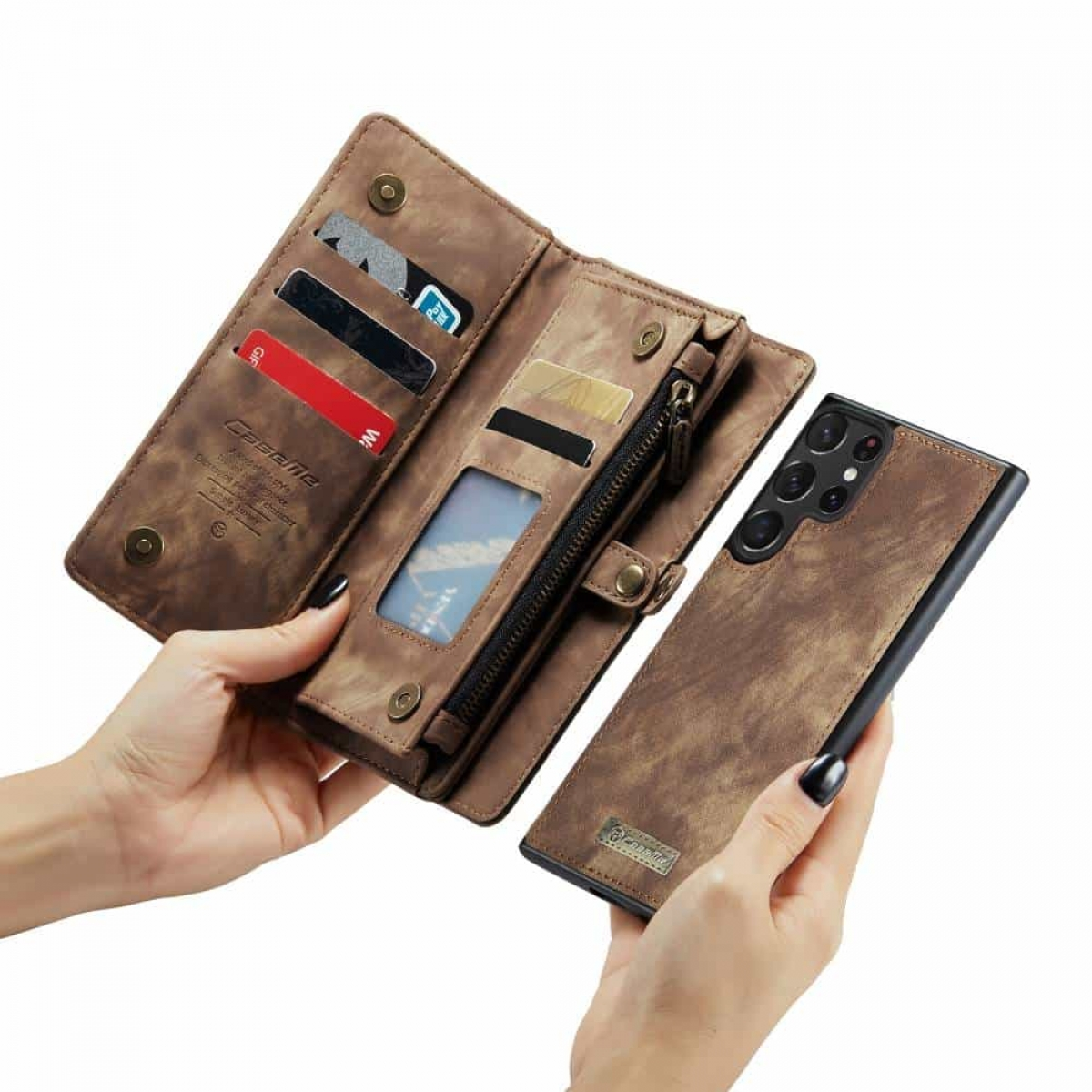 Hände einer Person halten eine braune Leder-Handyhülle mit Karten und einem Telefon.